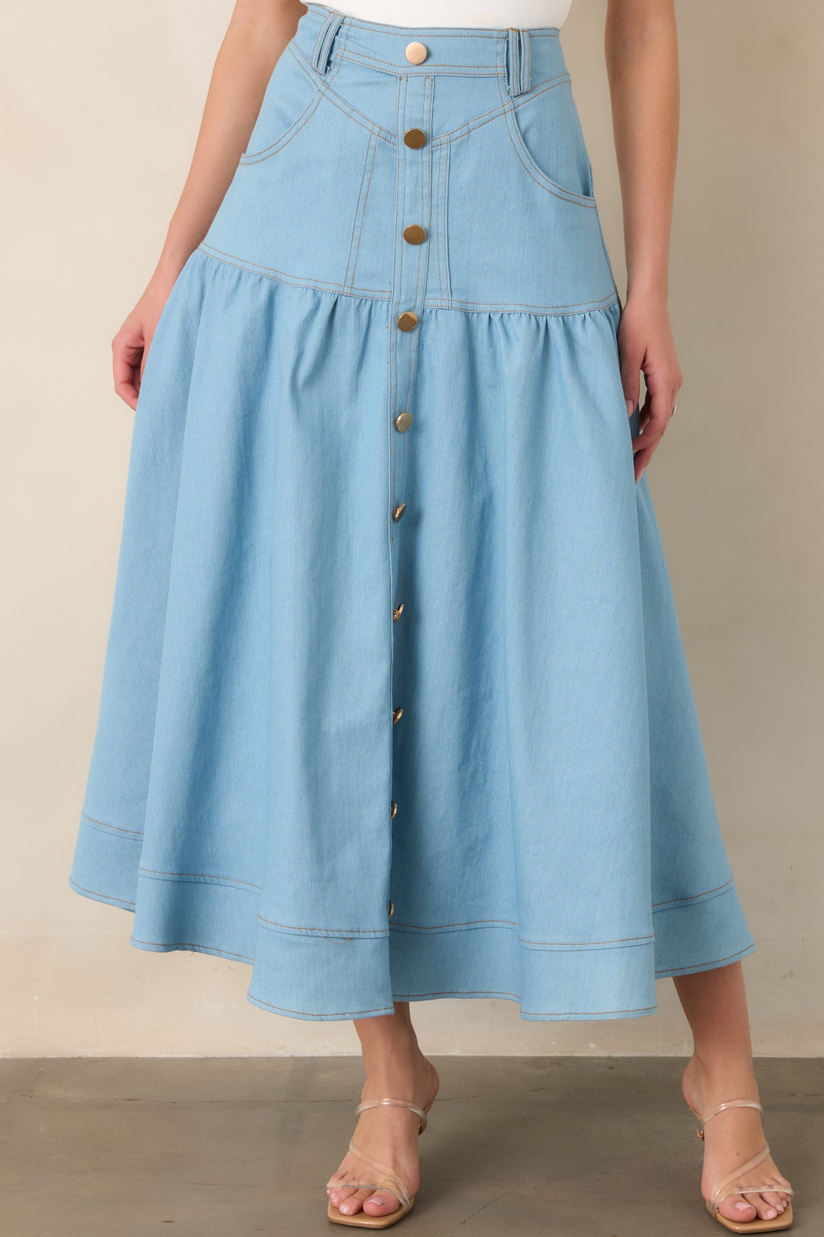 Detailed view of the light wash denim tiers and front pocket, showcasing the contrast topstitching and softly flared shape.