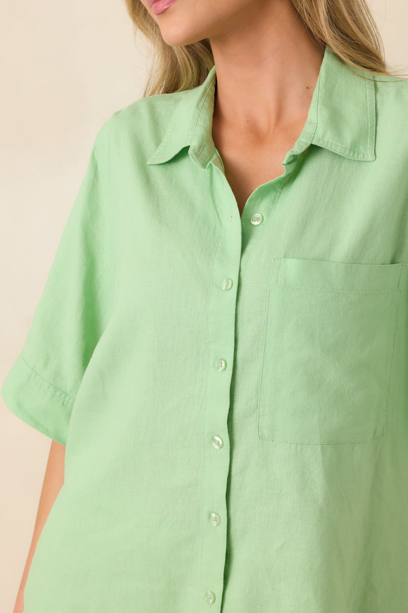 Light green material with buttons and stitched chest pocket detail.