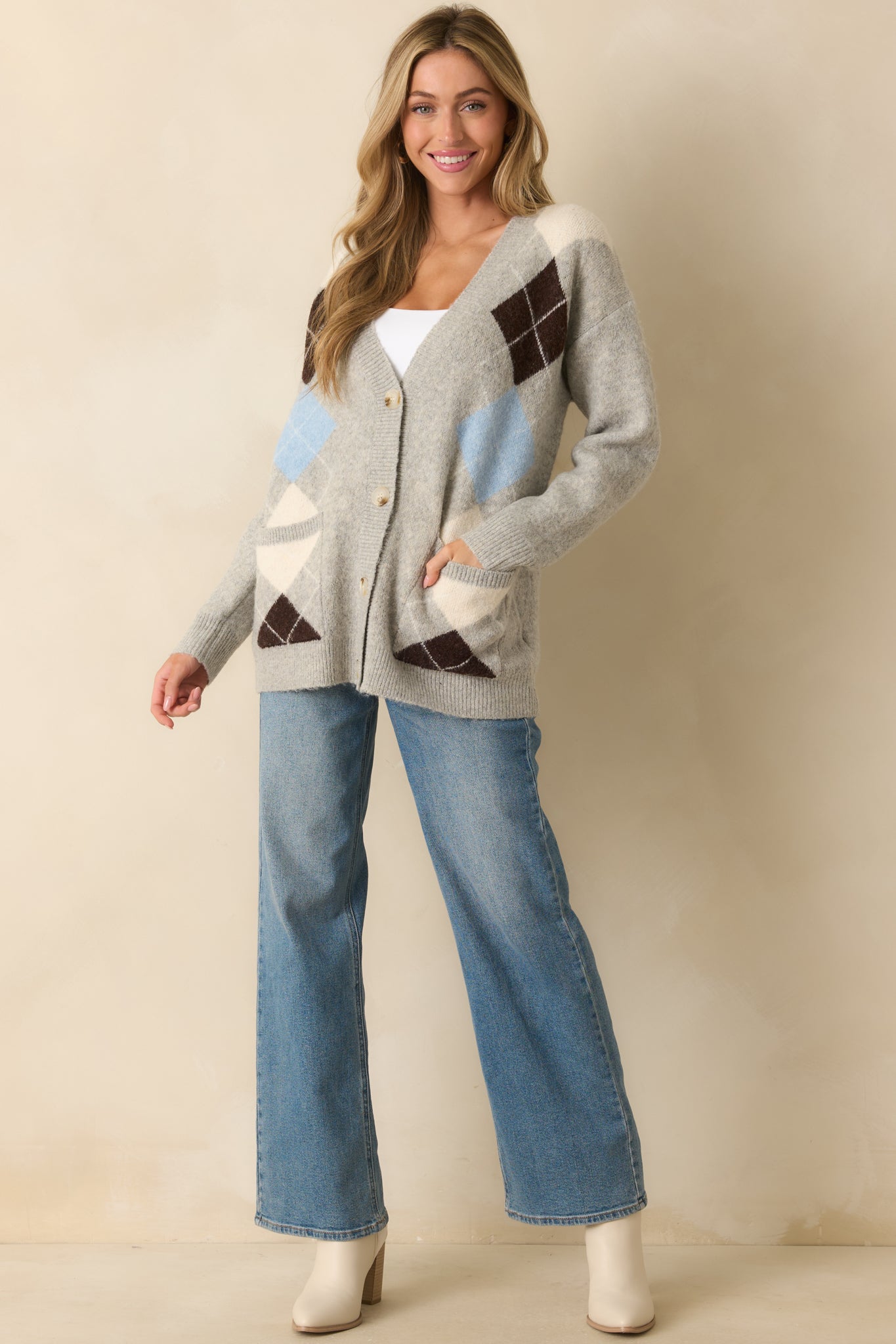 A full body angled front view showing the oversized fit and soft knit texture of the light grey cardigan.