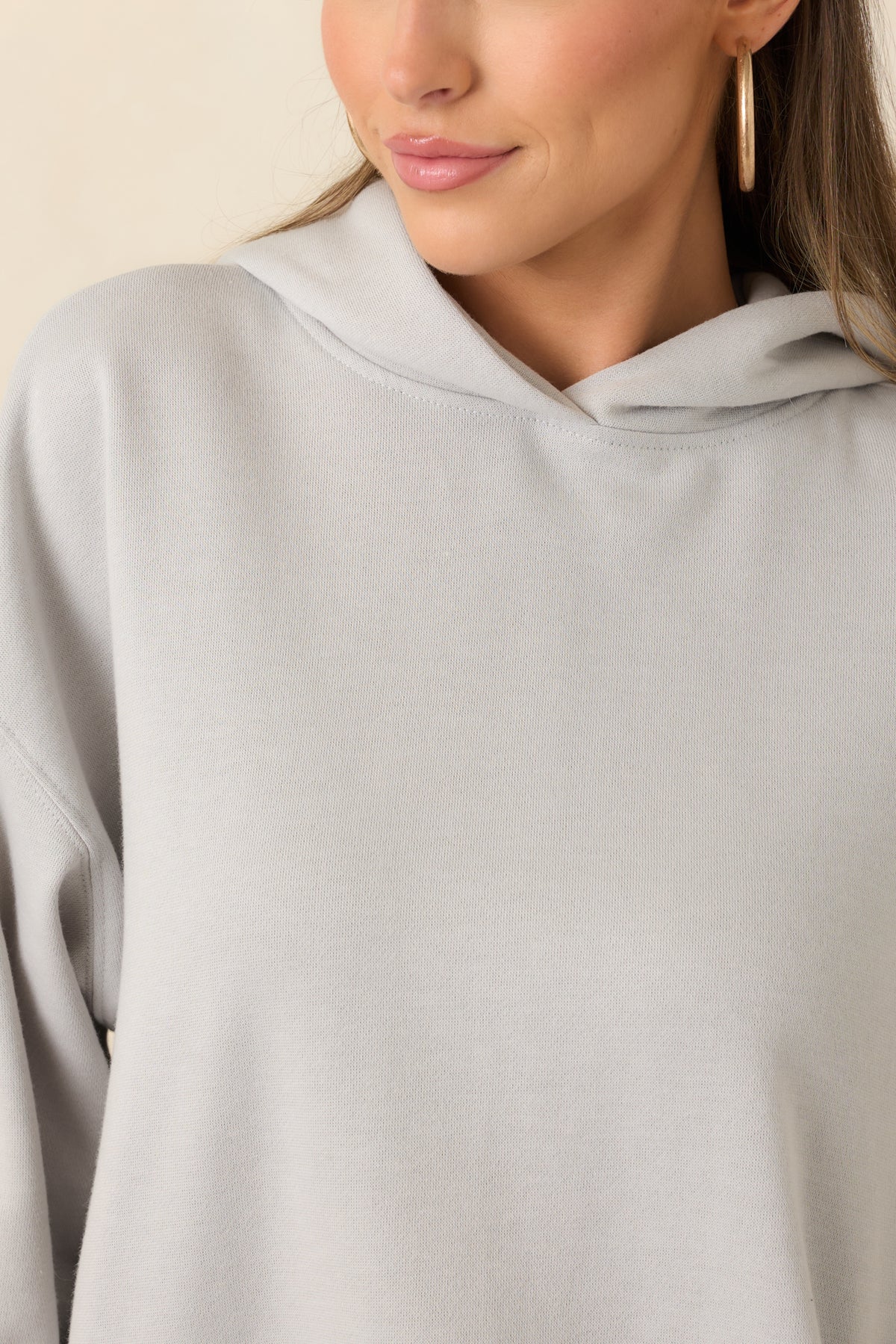Close detail of the light grey hoodie’s soft fleece texture and ribbed fabric trim.