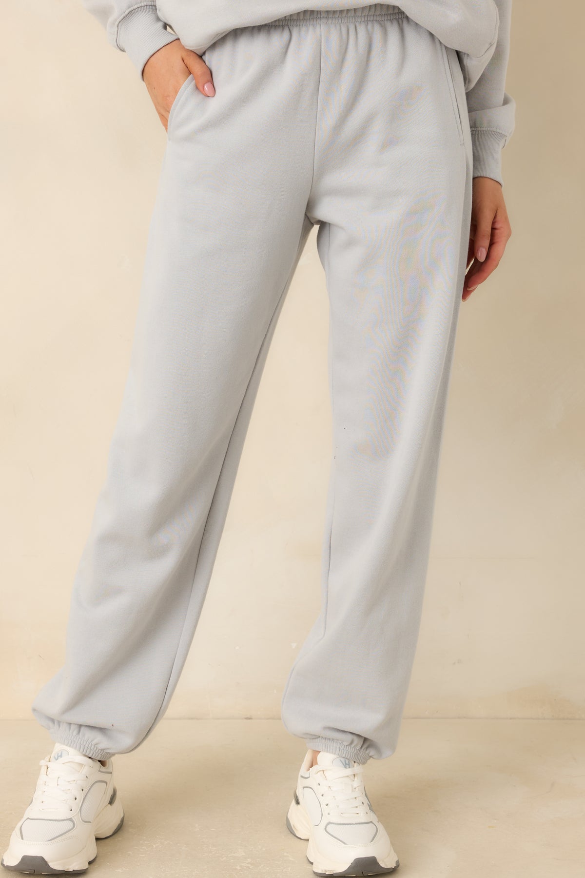 Light grey joggers featuring functional side pockets and a relaxed fit through the hips.