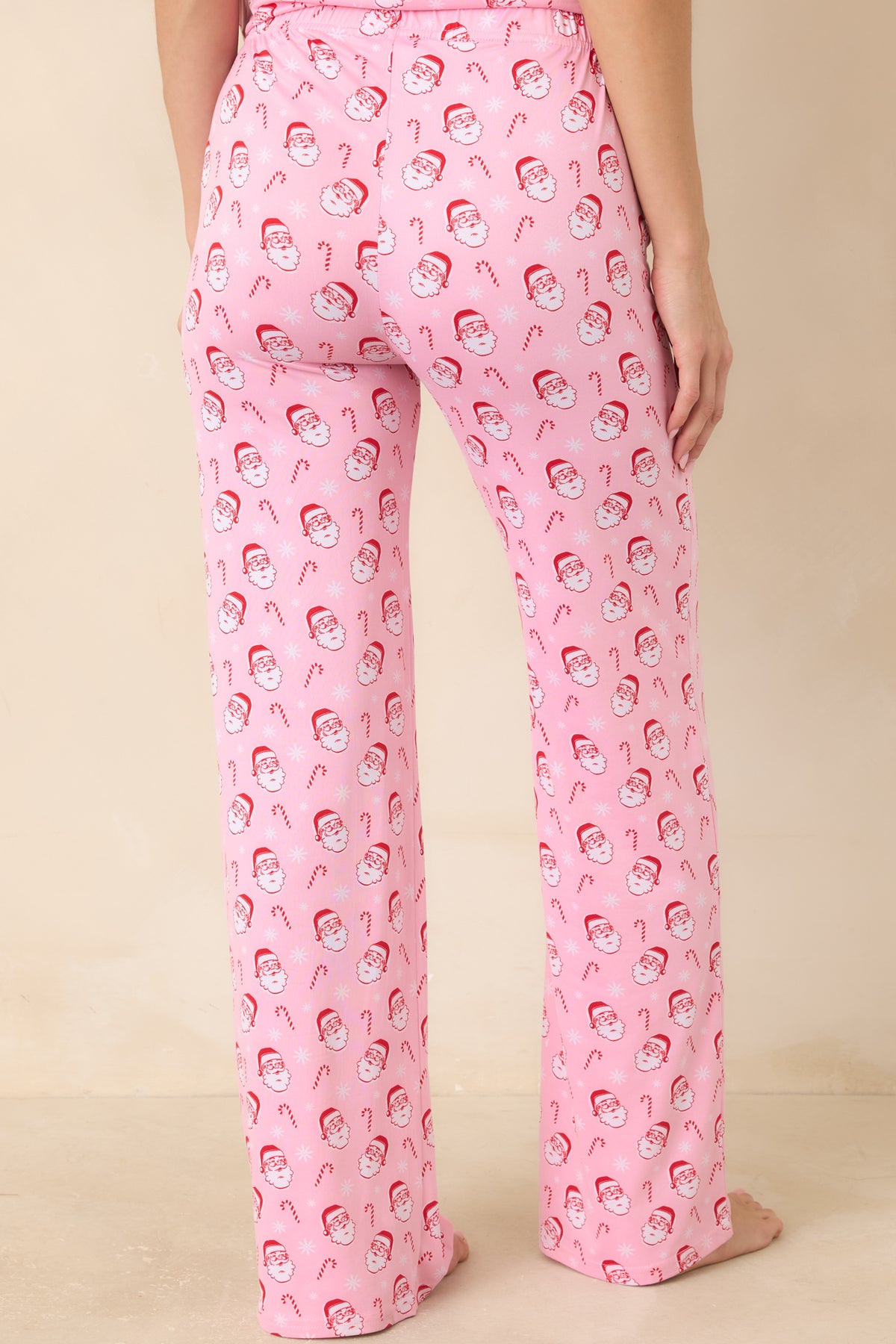 Rear of the light pink pajama pants showcases the allover Santa and candy cane print with a relaxed full-length fit.