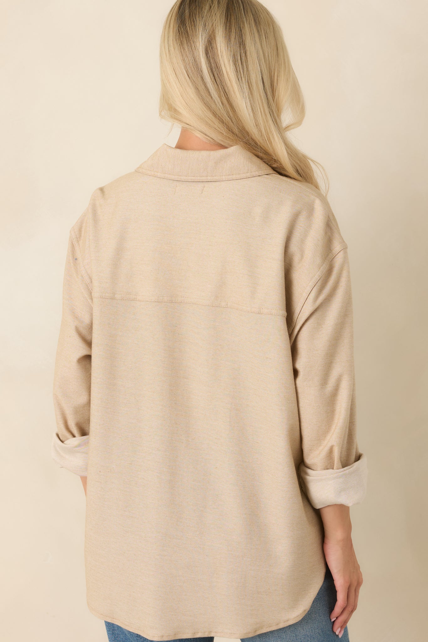 Rear view of the light toffee button-up top featuring a relaxed silhouette and curved hemline.