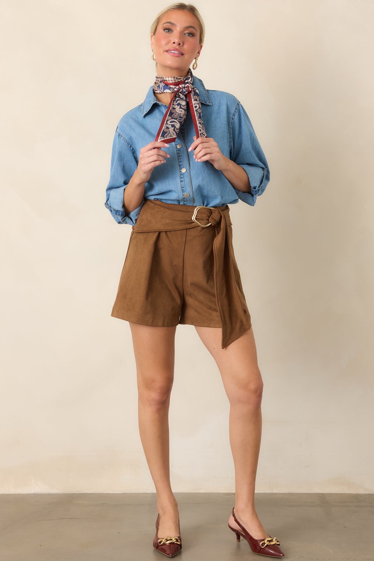 Light-wash cotton shirt showcasing its button closure, collared neckline, relaxed sleeves, and curved hemline.