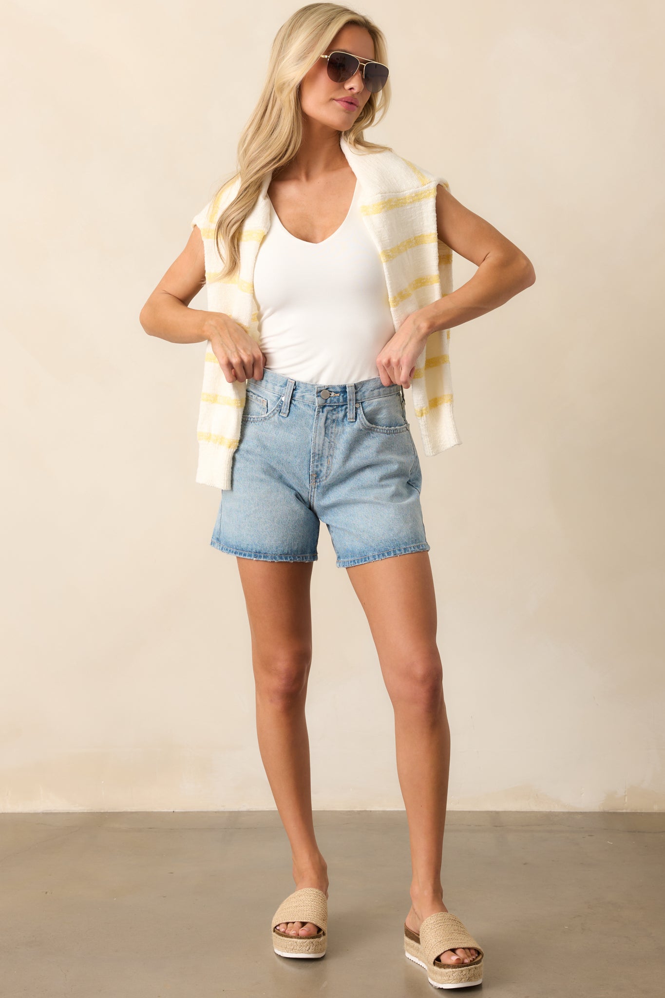 Light wash denim shorts with a high-rise waist, featuring a structured fit, functional five-pocket design, and a classic button-zipper closure.
