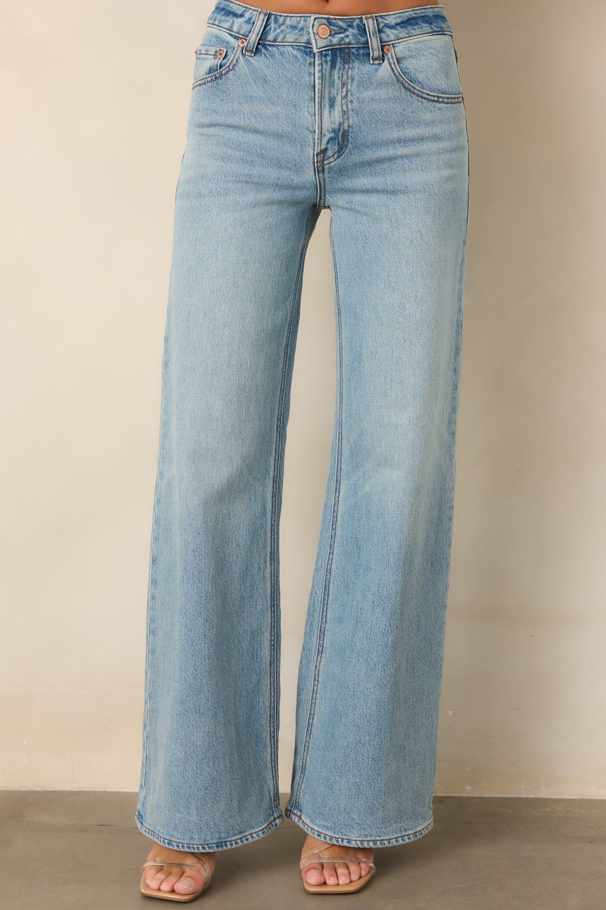 Light-wash jeans showcasing the mid-rise waist, belt loops, and classic button and zipper closure.