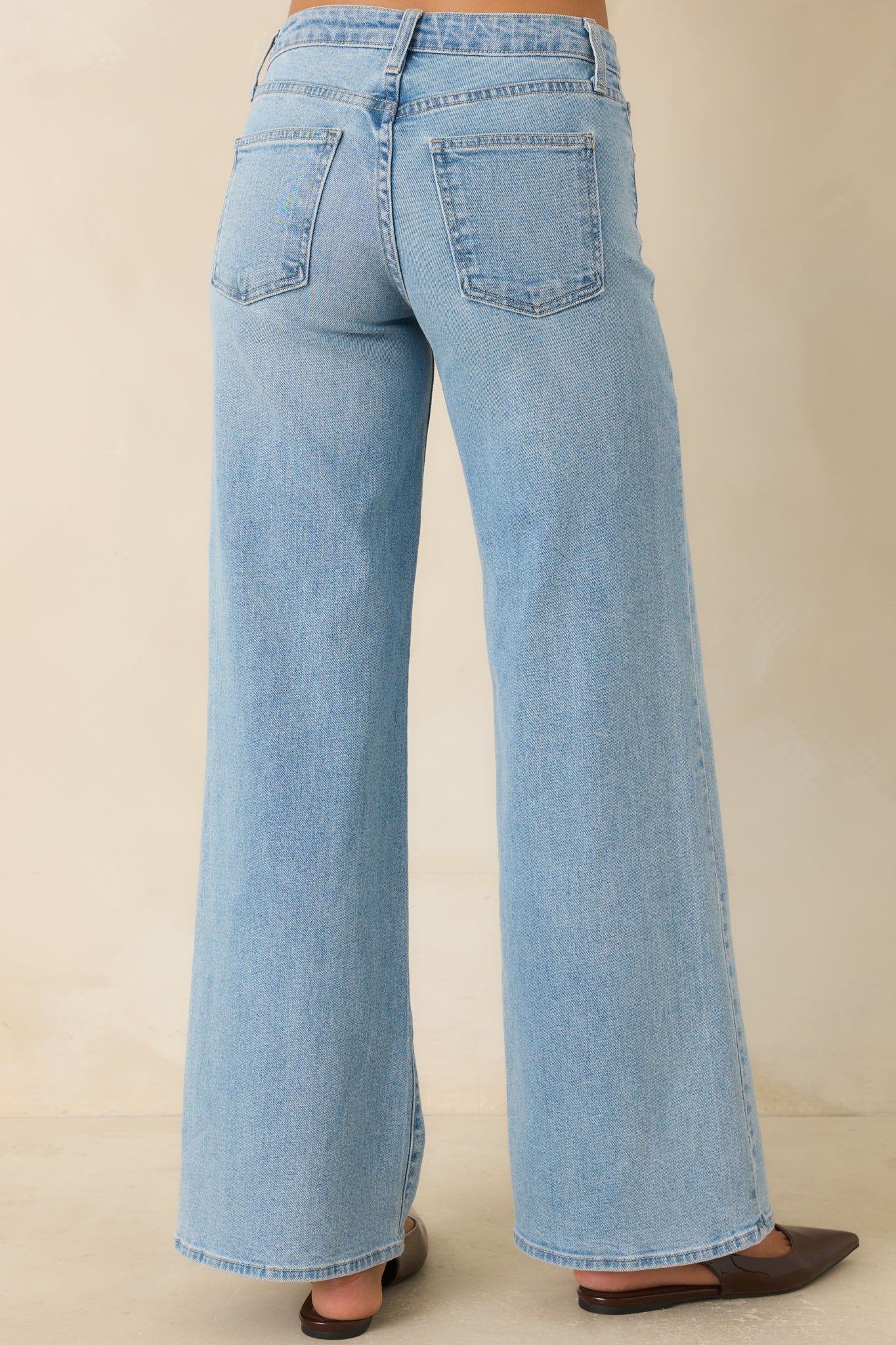 Rear view of the light wash straight leg jeans featuring a relaxed fit and back pocket details.