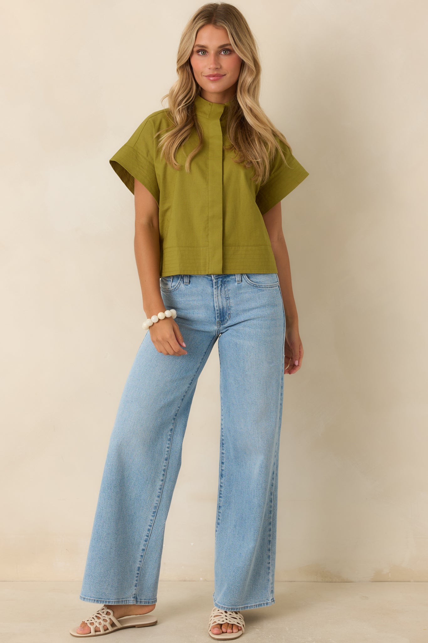 Lightweight cotton linen top showcasing a mock neckline, cuffed short sleeves, and clean tailoring for an effortlessly polished look.