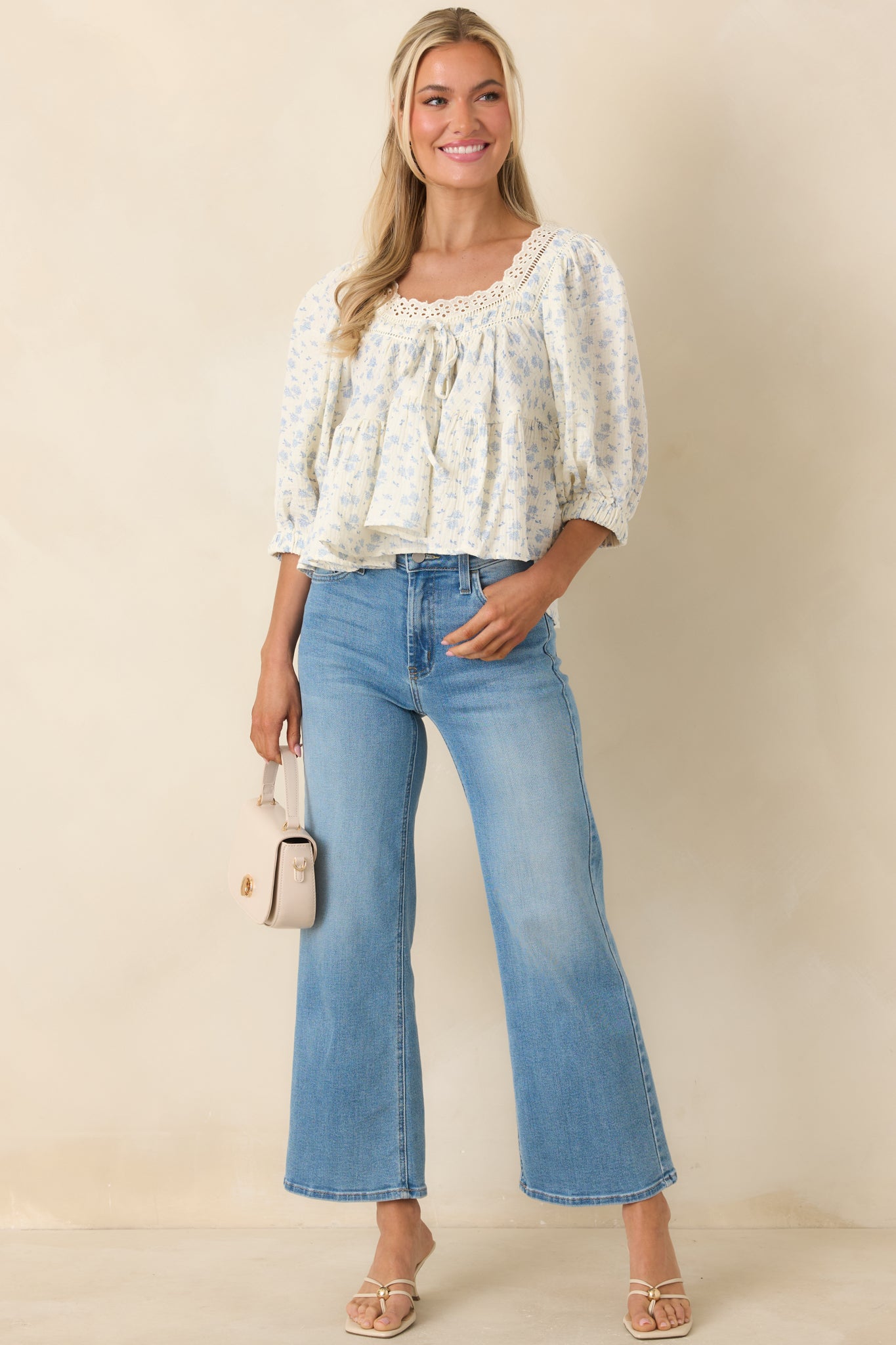 Lightweight floral blouse with textured eyelet trim and feminine flowing shape.