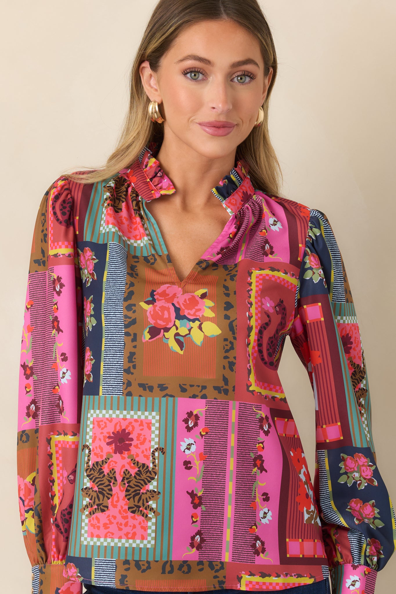 Close view of the lightweight printed top showcasing its softly gathered shoulders, fluid fabric, and bold patchwork-inspired pattern.