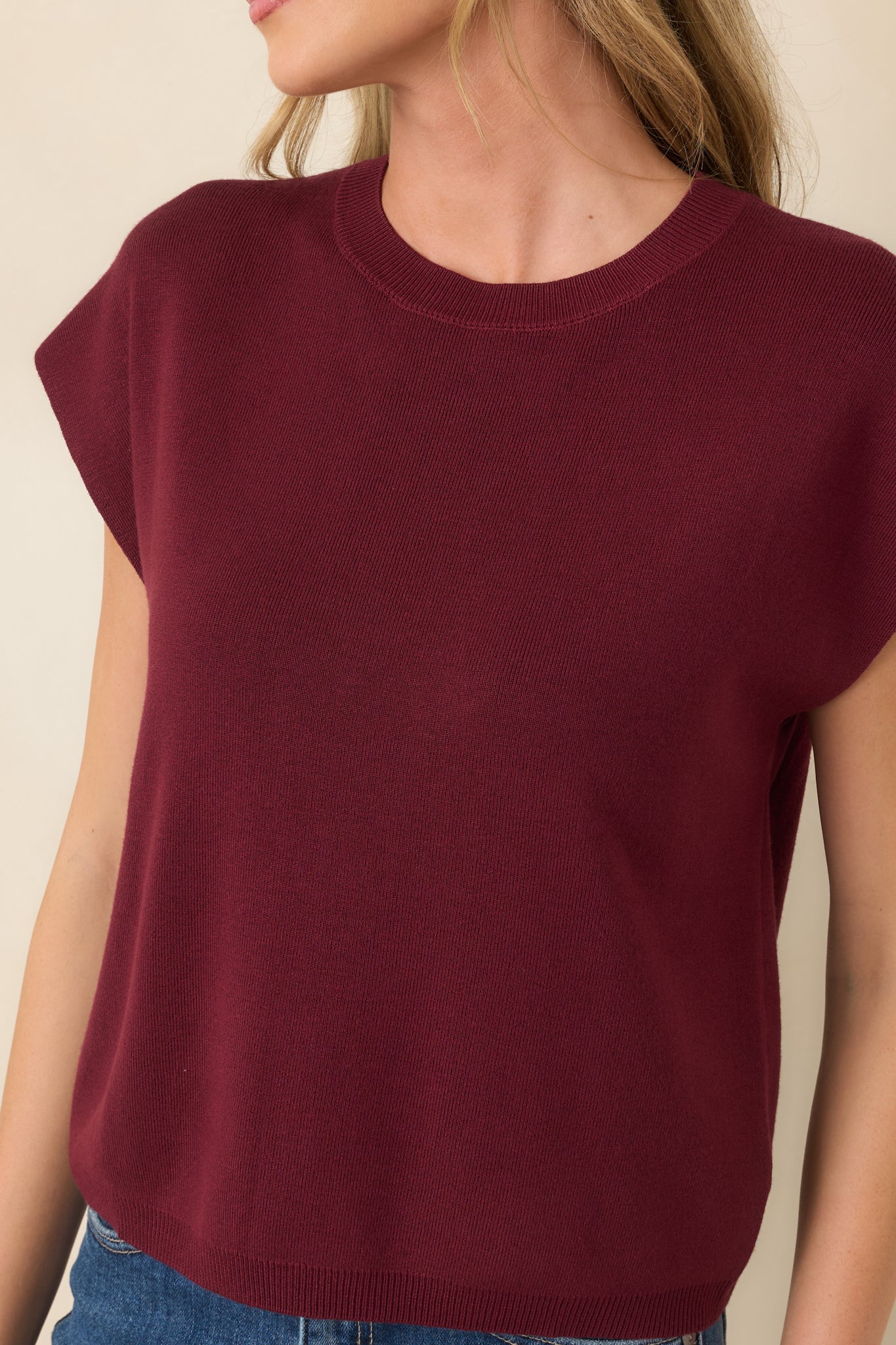 Close-up of the lightweight knit fabric and ribbed crew neckline, highlighting the soft texture and refined finishing details.
