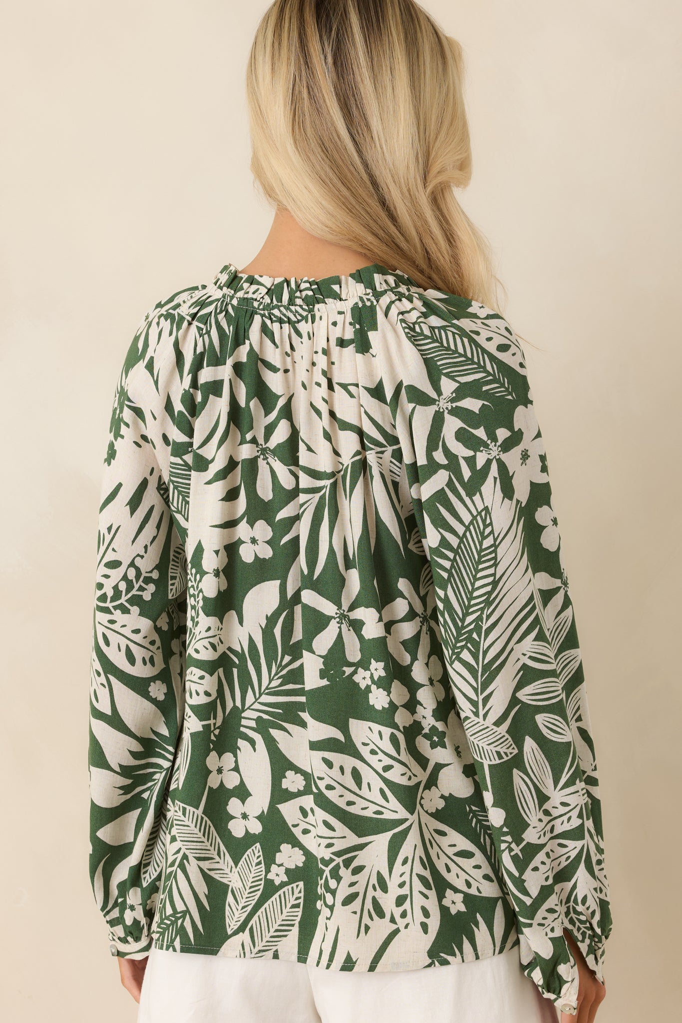 Back view of green jungle print top showing long sleeves, button cuffs, and lightweight silhouette