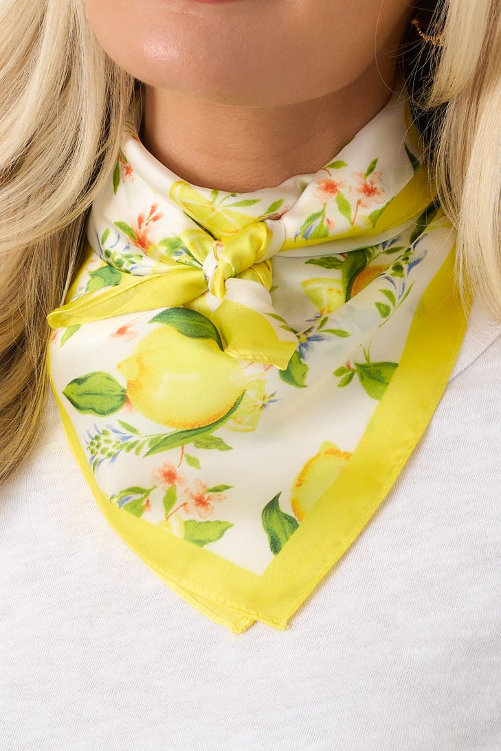 Lightweight scarf showcasing vibrant yellow lemons, botanical details, and a polished sunny border design.