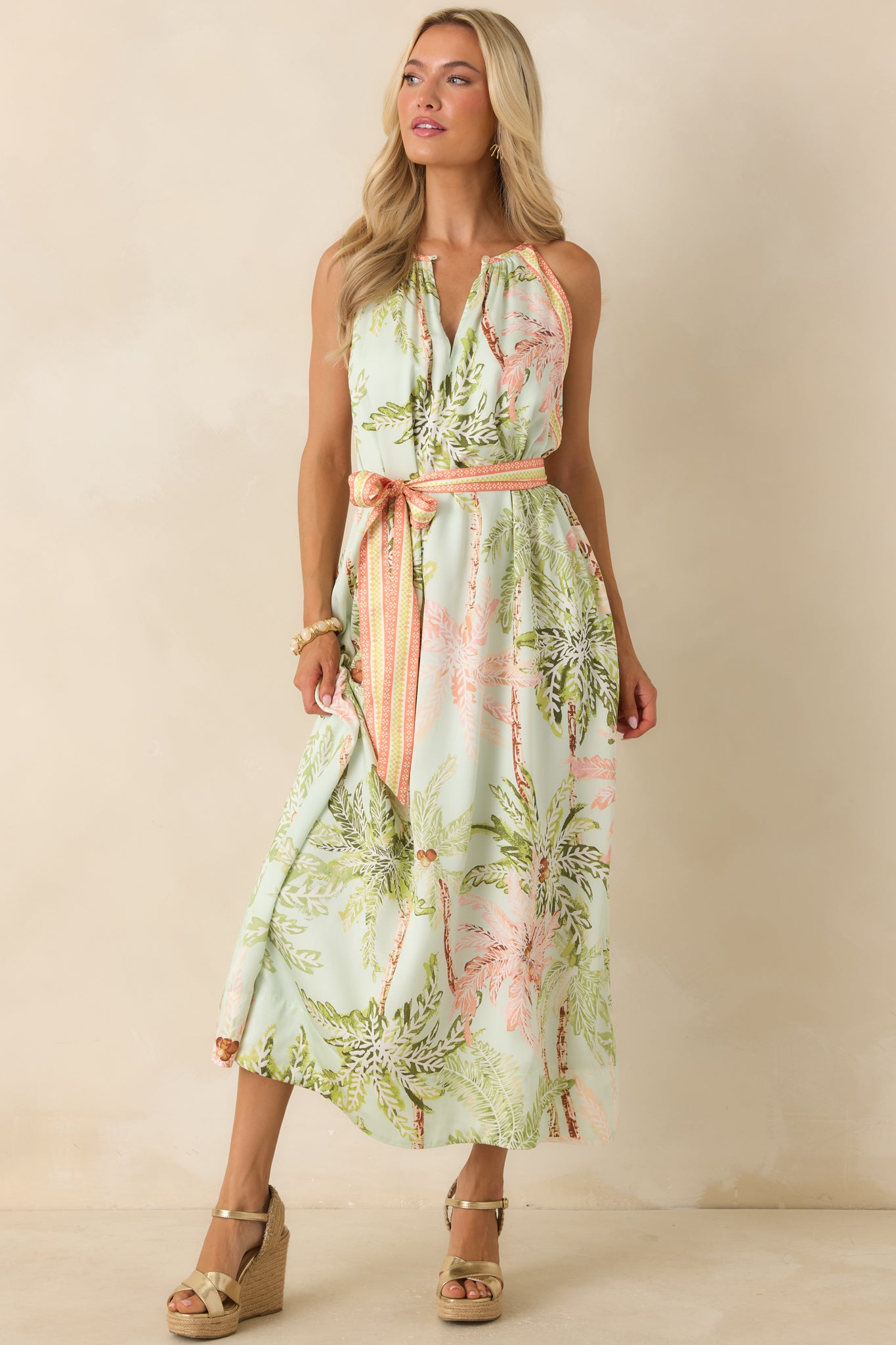 Lightweight sleeveless maxi dress featuring a cinched waist sash, delicate neckline gathers, and an airy, movement-friendly silhouette.