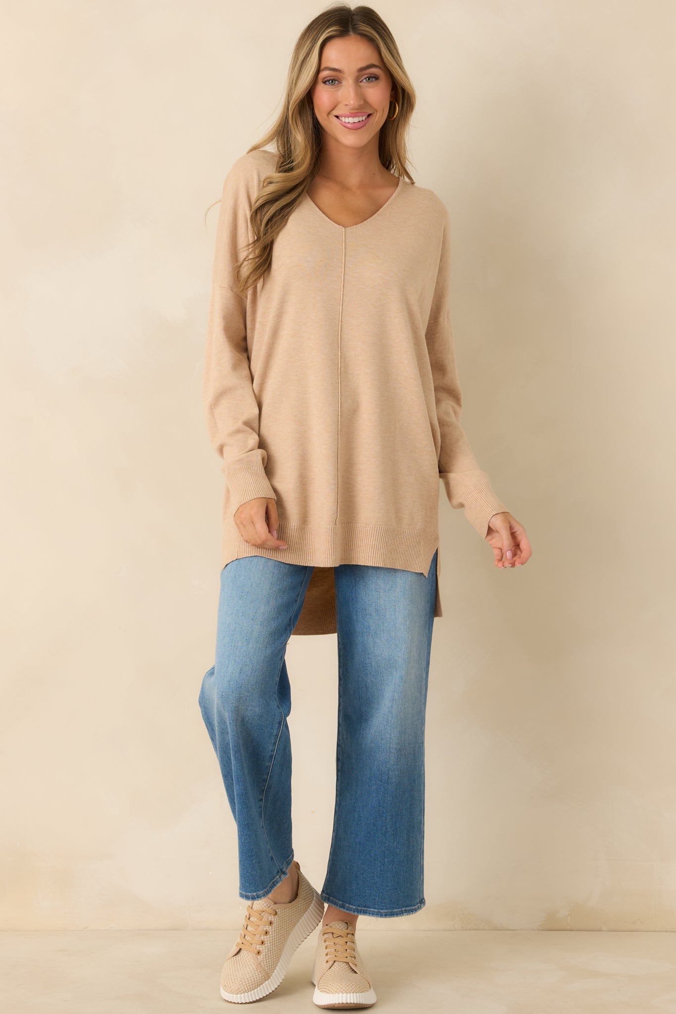Lightweight taupe sweater featuring side slits and a gently draping longline fit.