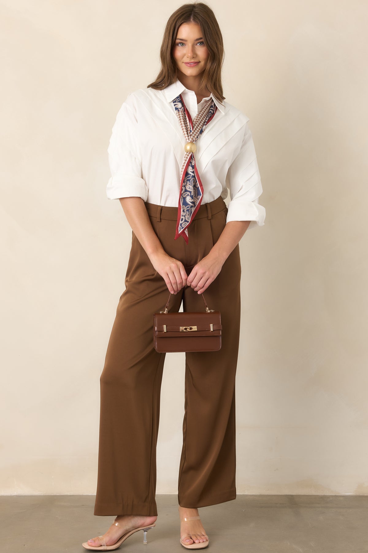 Lightweight white blouse with a full button closure, structured shoulders, and relaxed long sleeves.