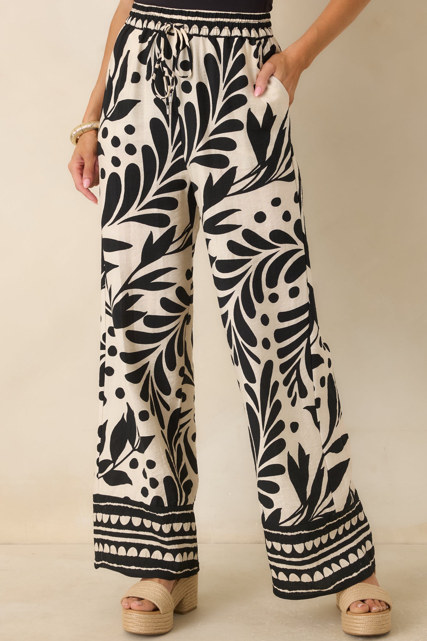 Detailed front view showcasing the lightweight woven fabric and relaxed wide-leg drape of the botanical print pants.
