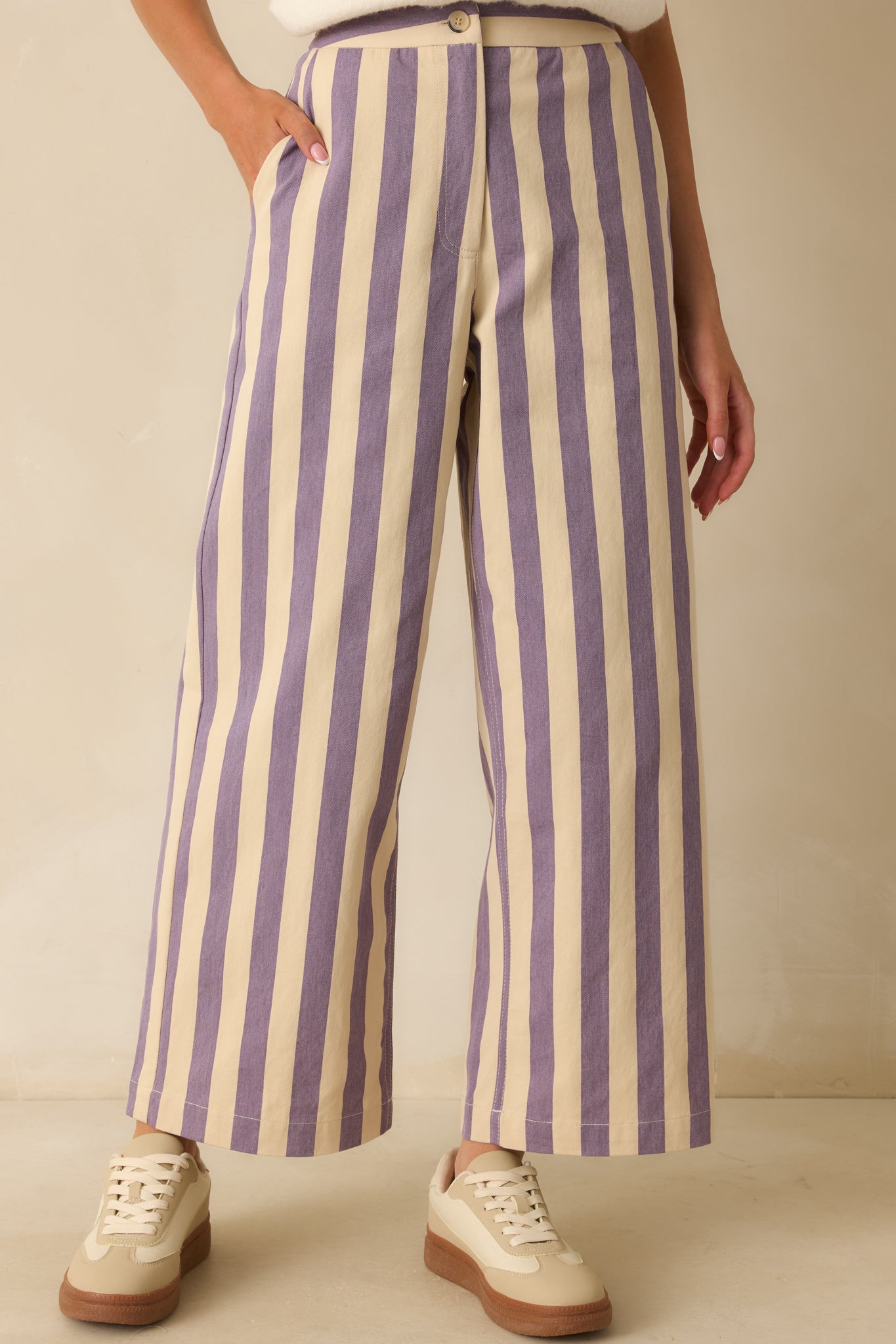 Focus on the vertical stripe pattern and front pocket detailing of the lilac and cream pants.
