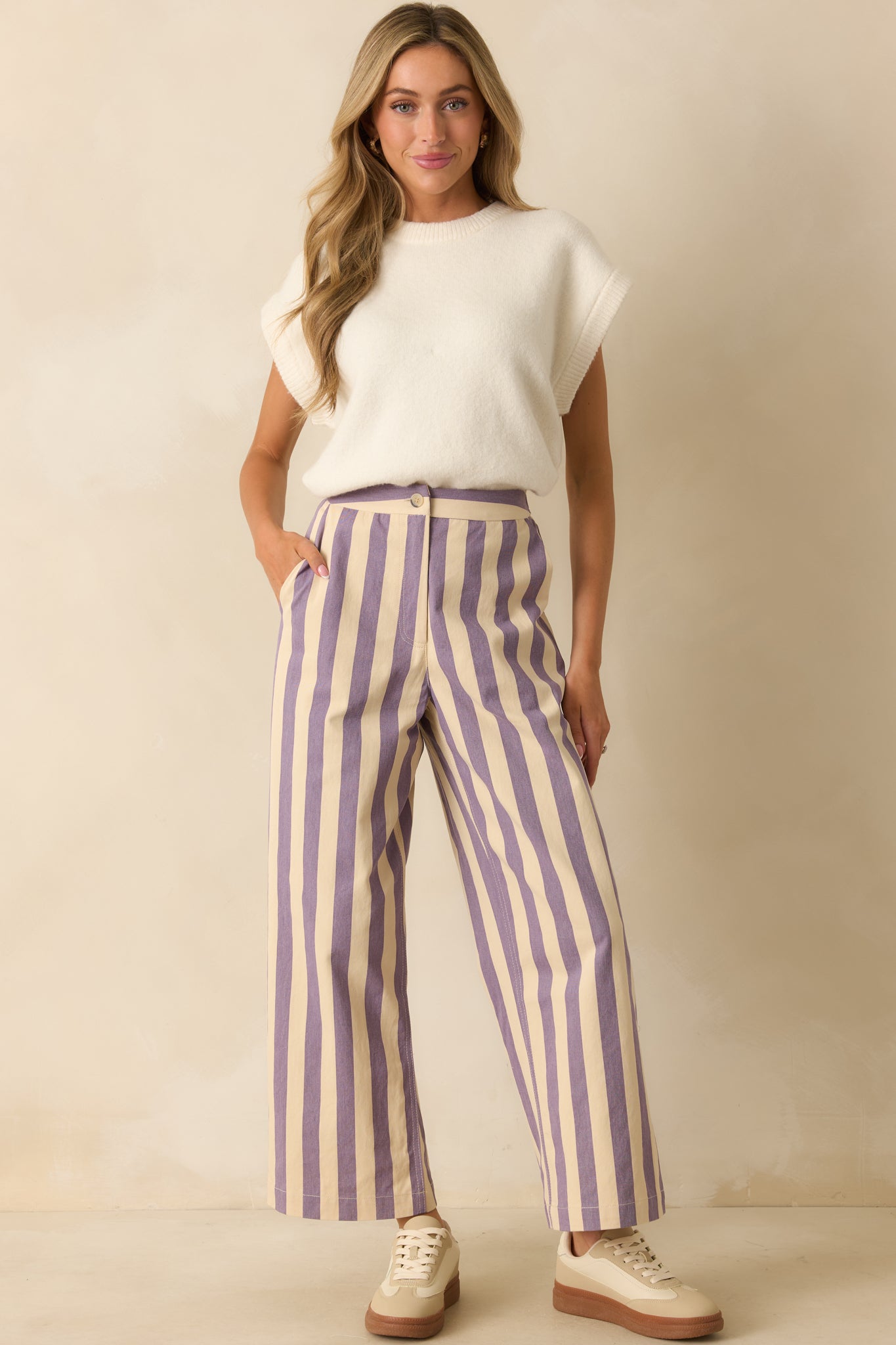 Lilac striped pants with a high-rise waist and wide-leg fit, showing their tailored yet easy silhouette.