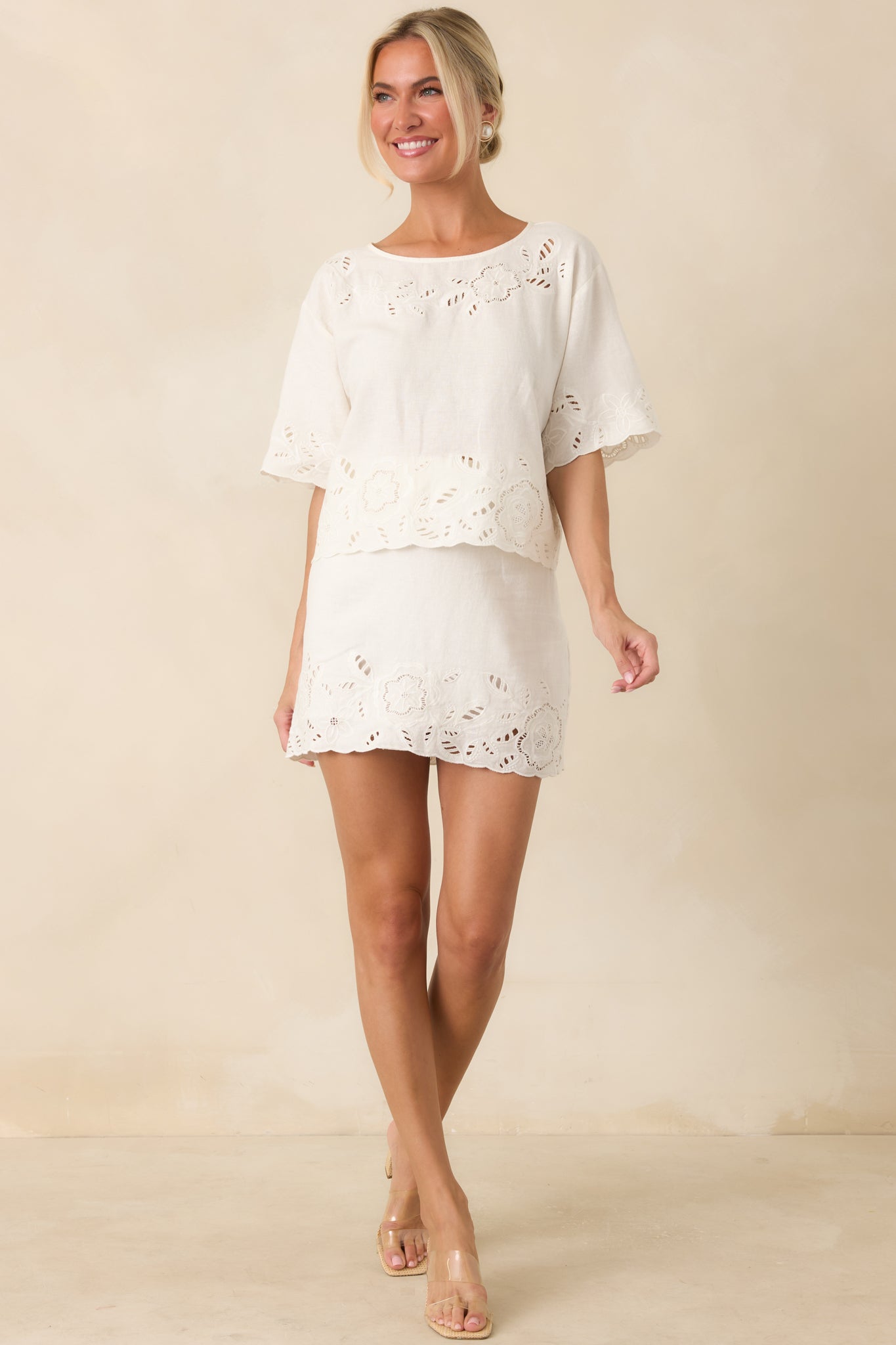 Airy linen-blend mini skirt designed with floral embroidery, a tailored high-rise silhouette, and a fully lined finish.