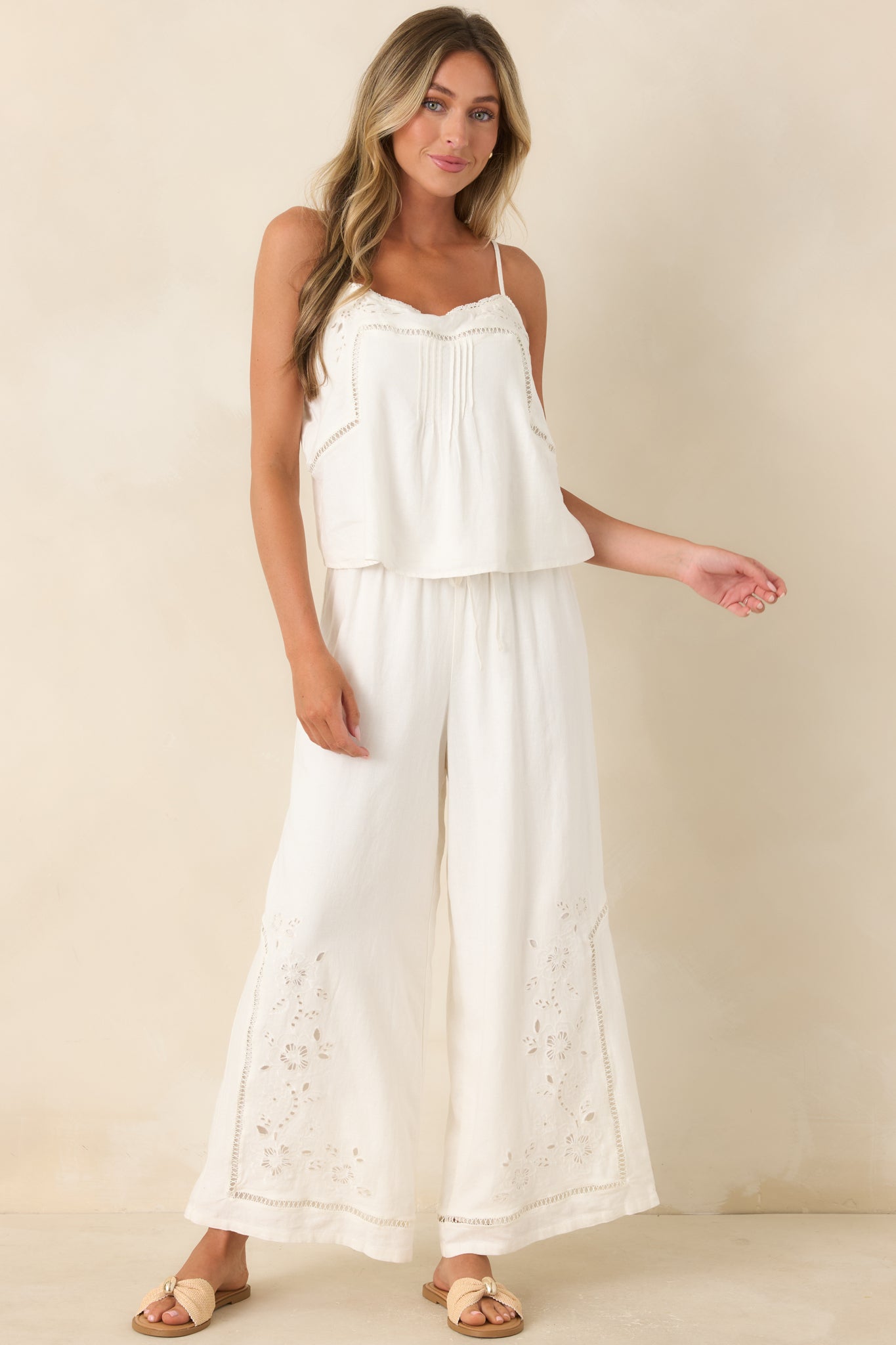Linen blend wide leg pants featuring a relaxed silhouette, elastic waistband, and floral embroidered lower leg details.