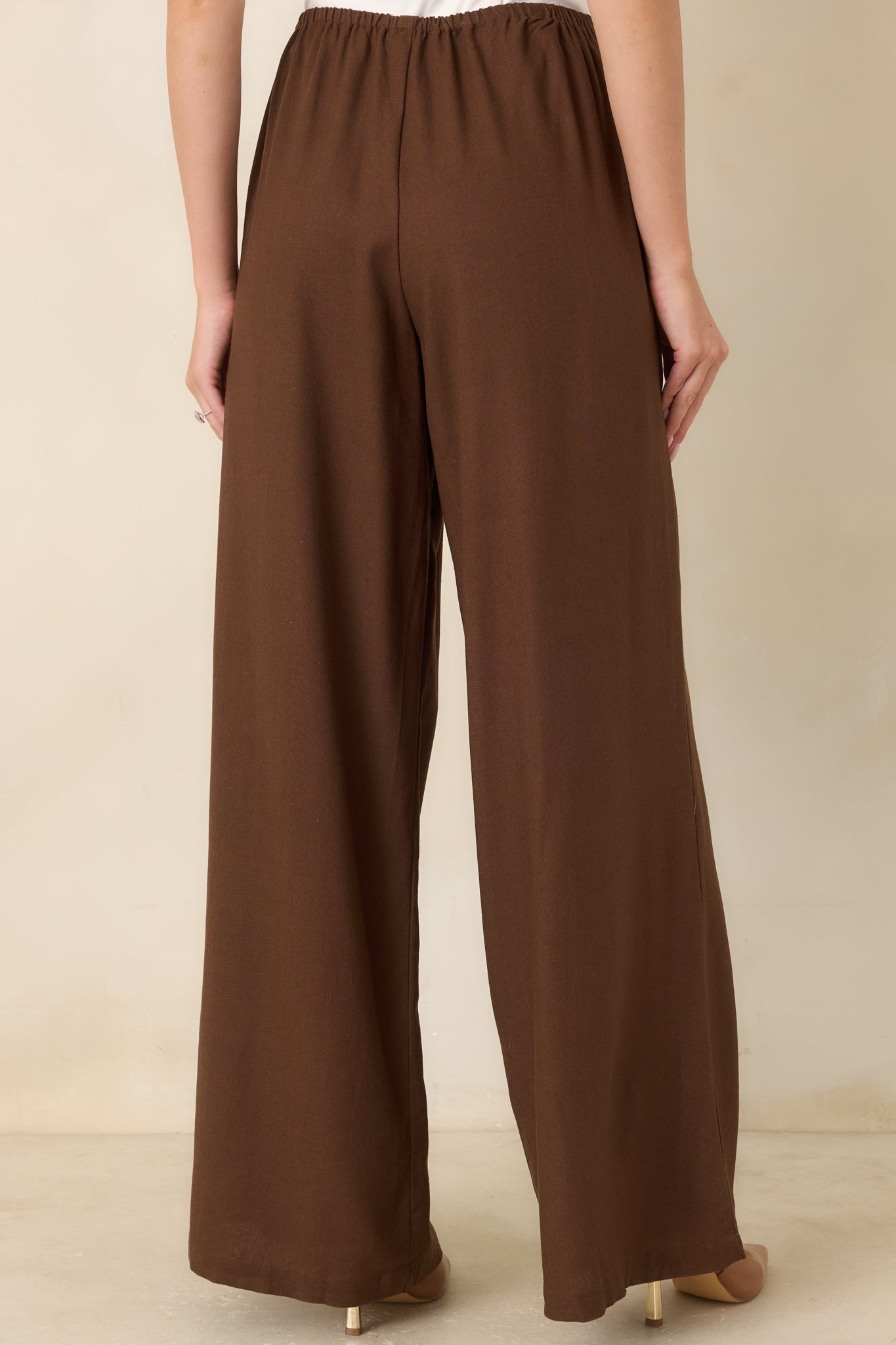 Rear view of the linen blend wide-leg pants featuring a smooth elastic waistband, relaxed fit, and flowing draped silhouette.
