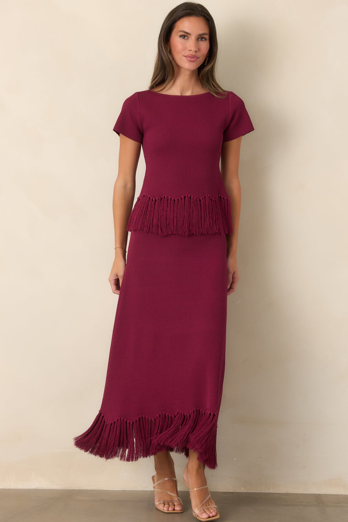 Long berry knit skirt featuring a softly fitted shape through the hips and fringed hem.