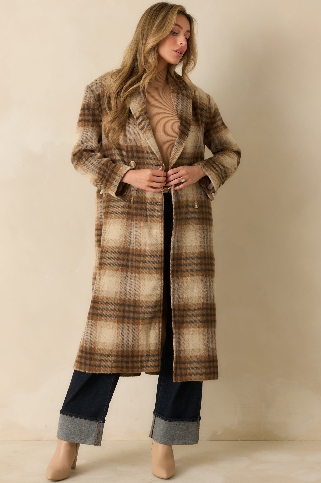 Long brown plaid overcoat with button front and side pockets, offering a timeless, polished look.
