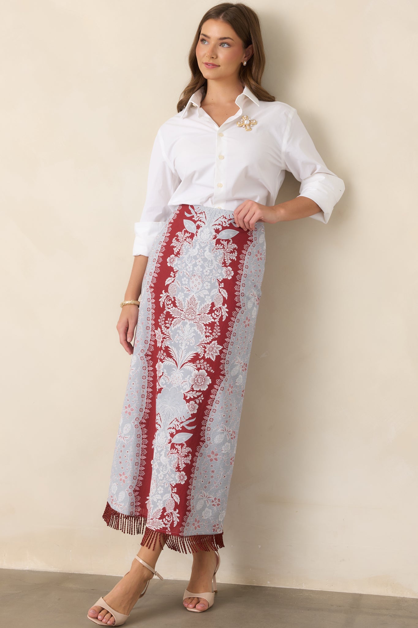Long cotton-linen skirt showcasing a refined column shape, high-rise waist, and fluid fringe trim extending along the hem.