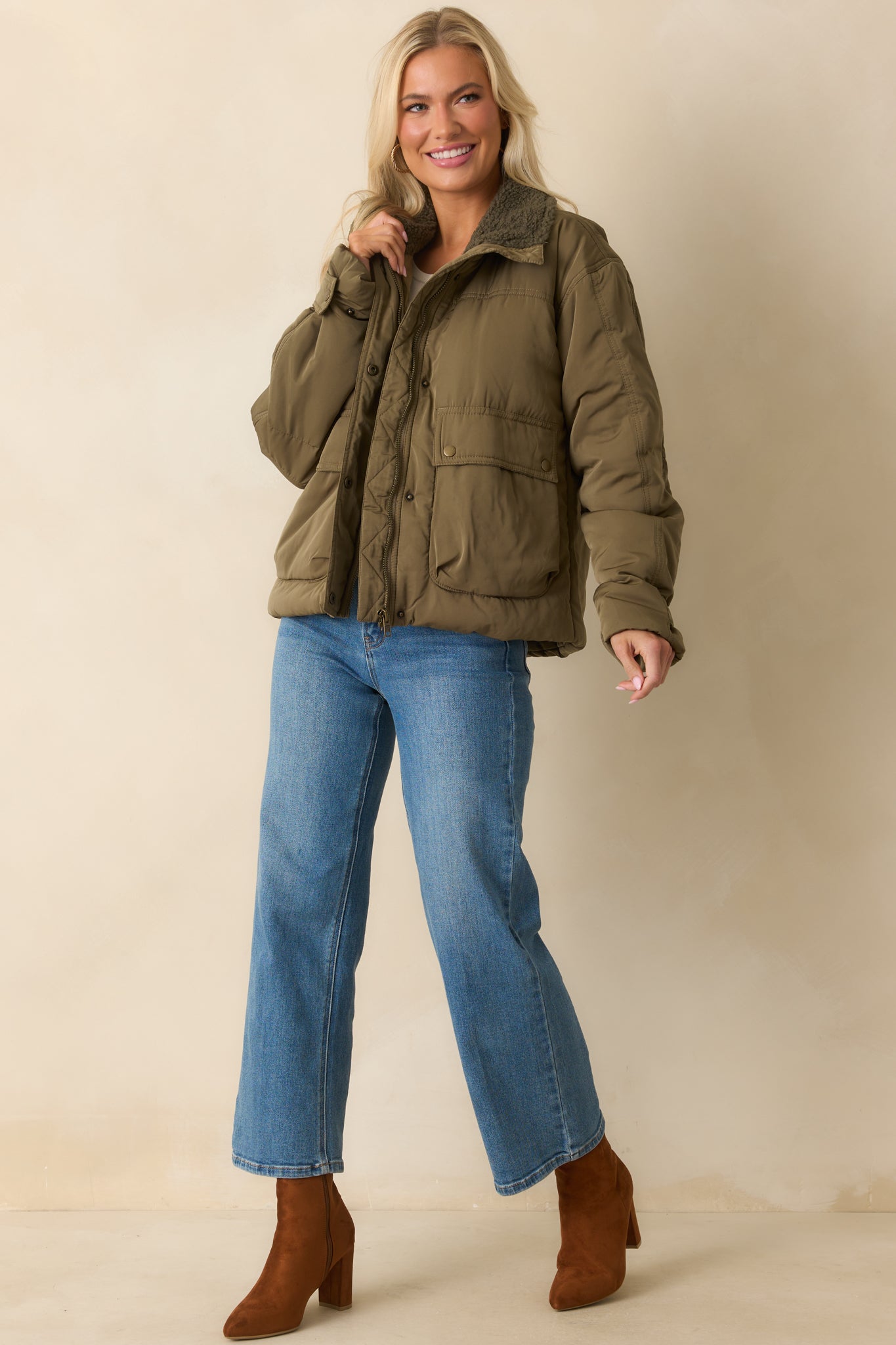 Long-sleeve puffer jacket in army green featuring functional patch pockets and snap button cuffs.