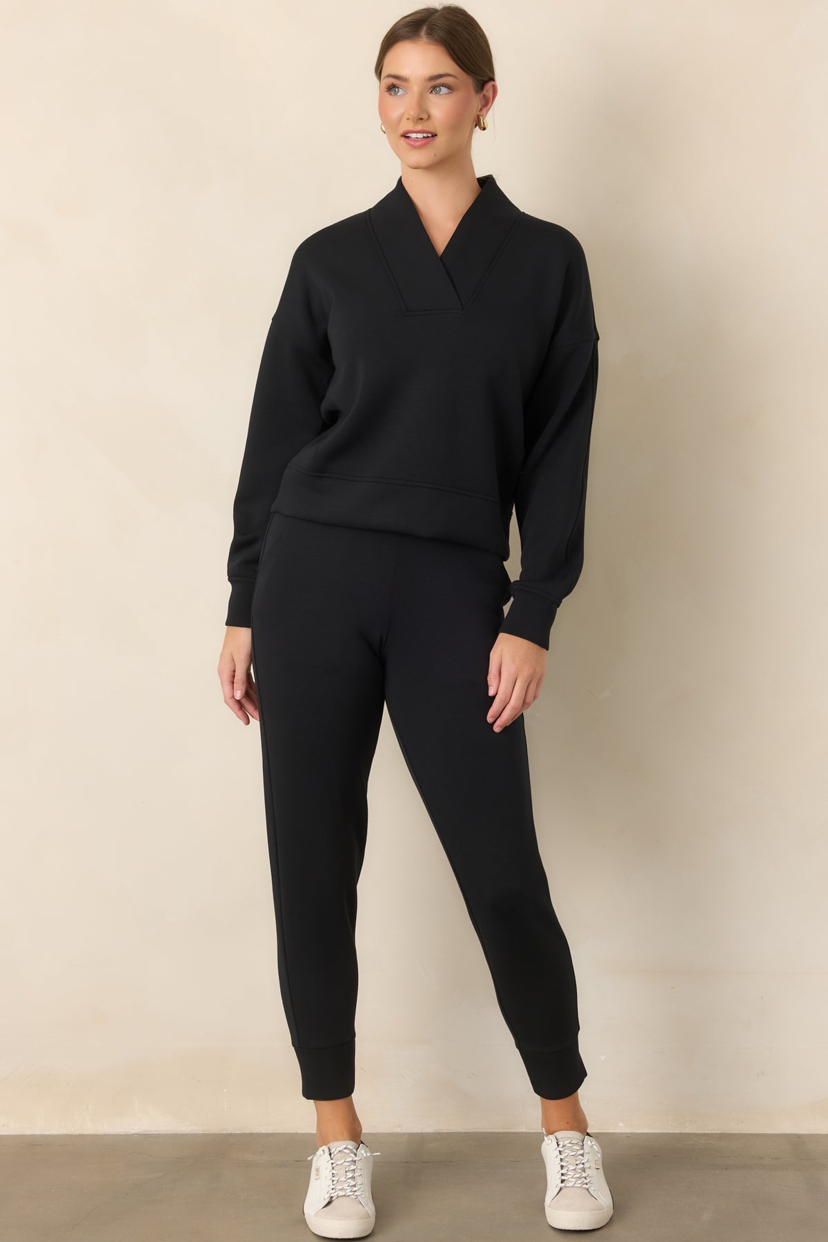 Long-sleeve top showcasing a structured V-neck, oversized collar, dropped shoulder seams, and banded cuffs.