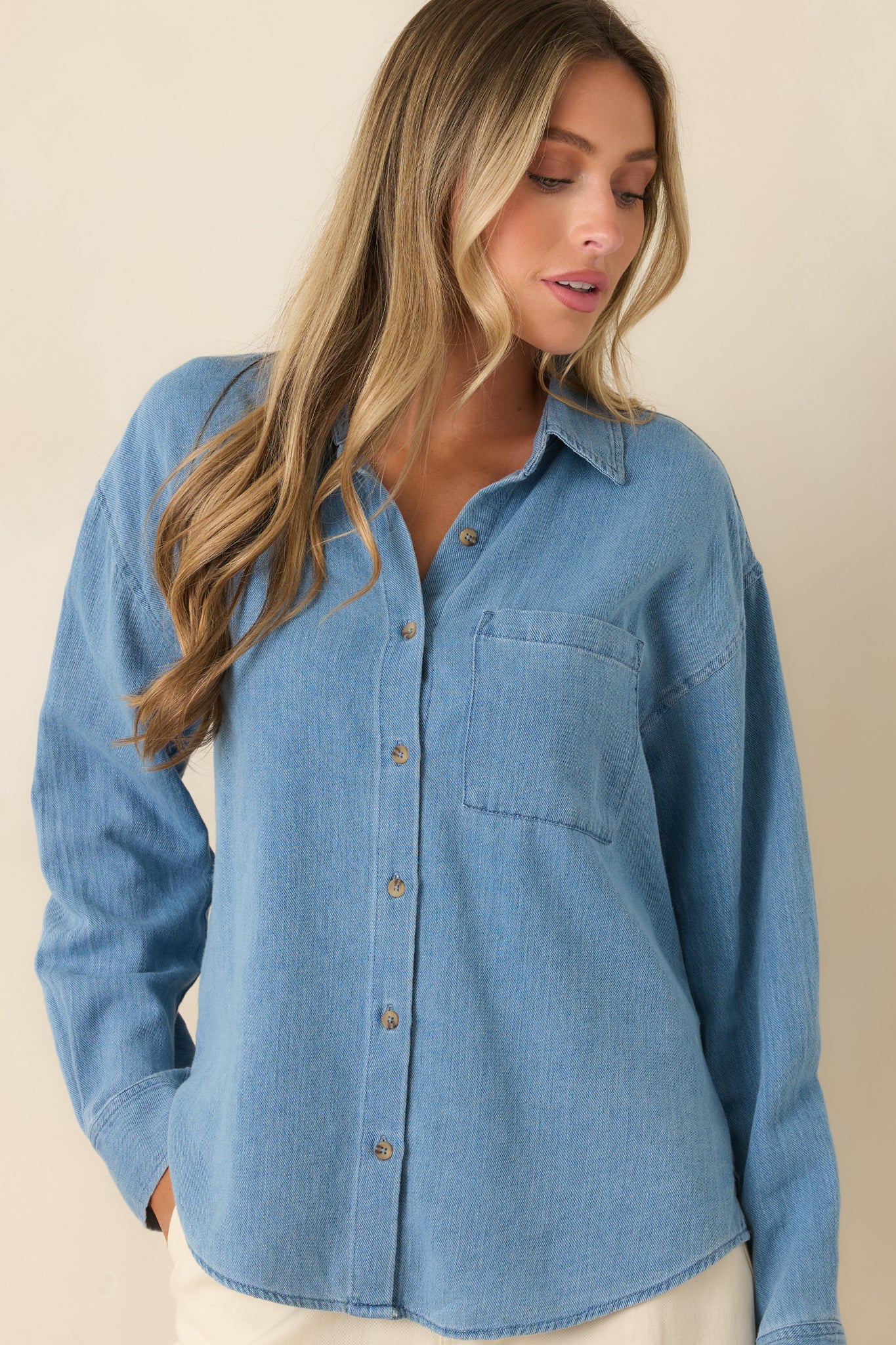 Long sleeve top showcasing button cuffs, a classic collar, and clean front detailing.
