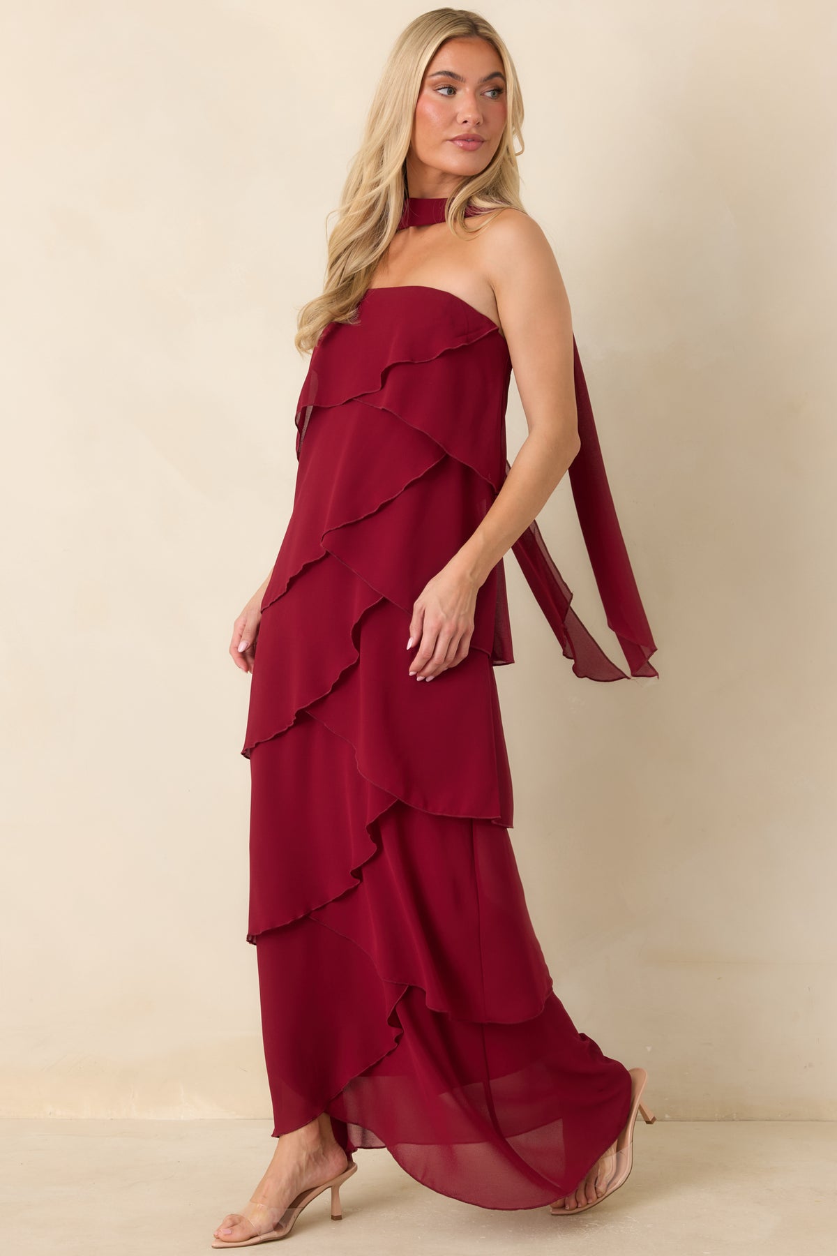 Long wine red strapless dress with cascading ruffles and a scarf trailing down the back.