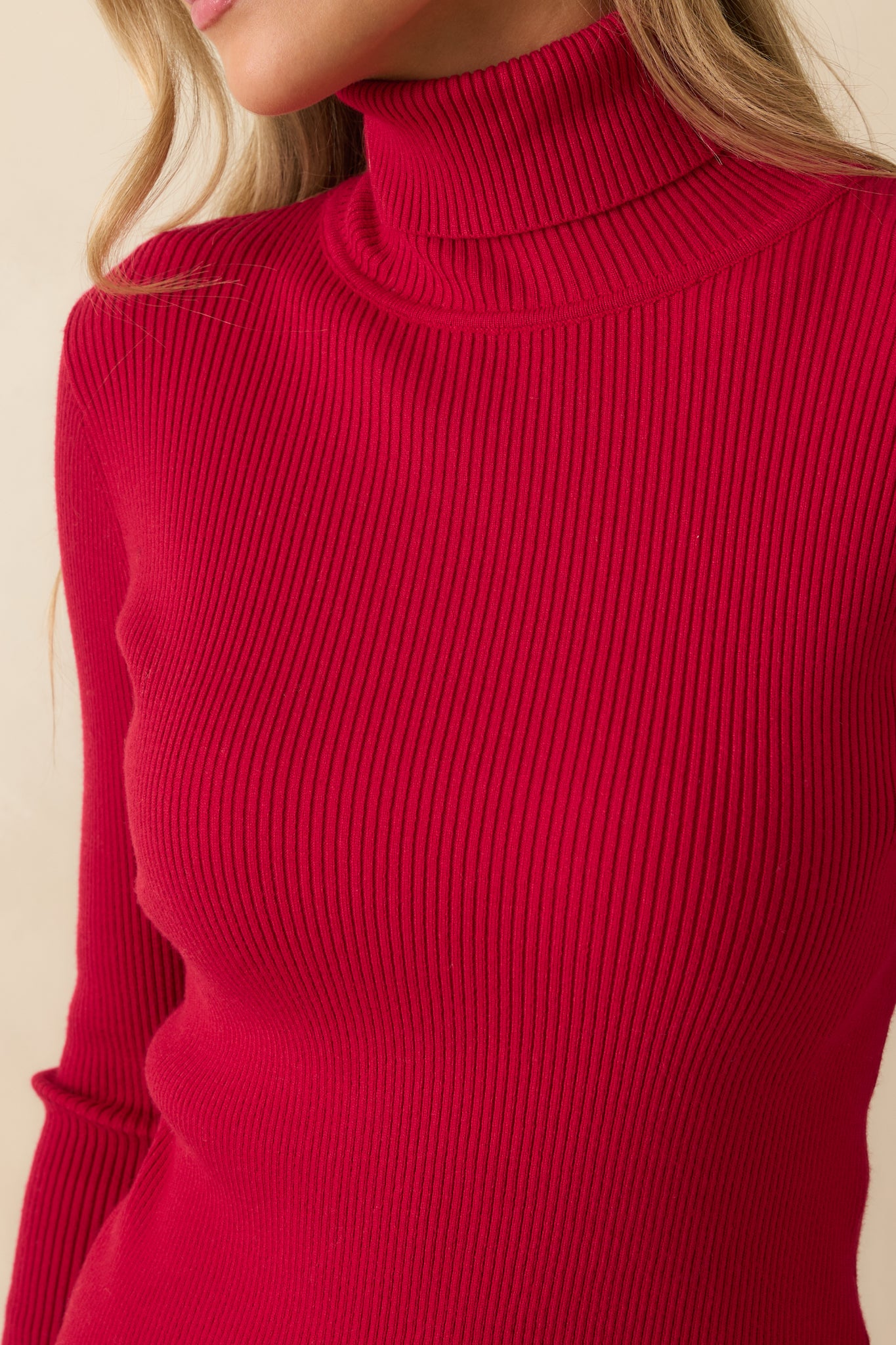 Macro view of ribbed knit fabric and foldover turtleneck on the red sweater.