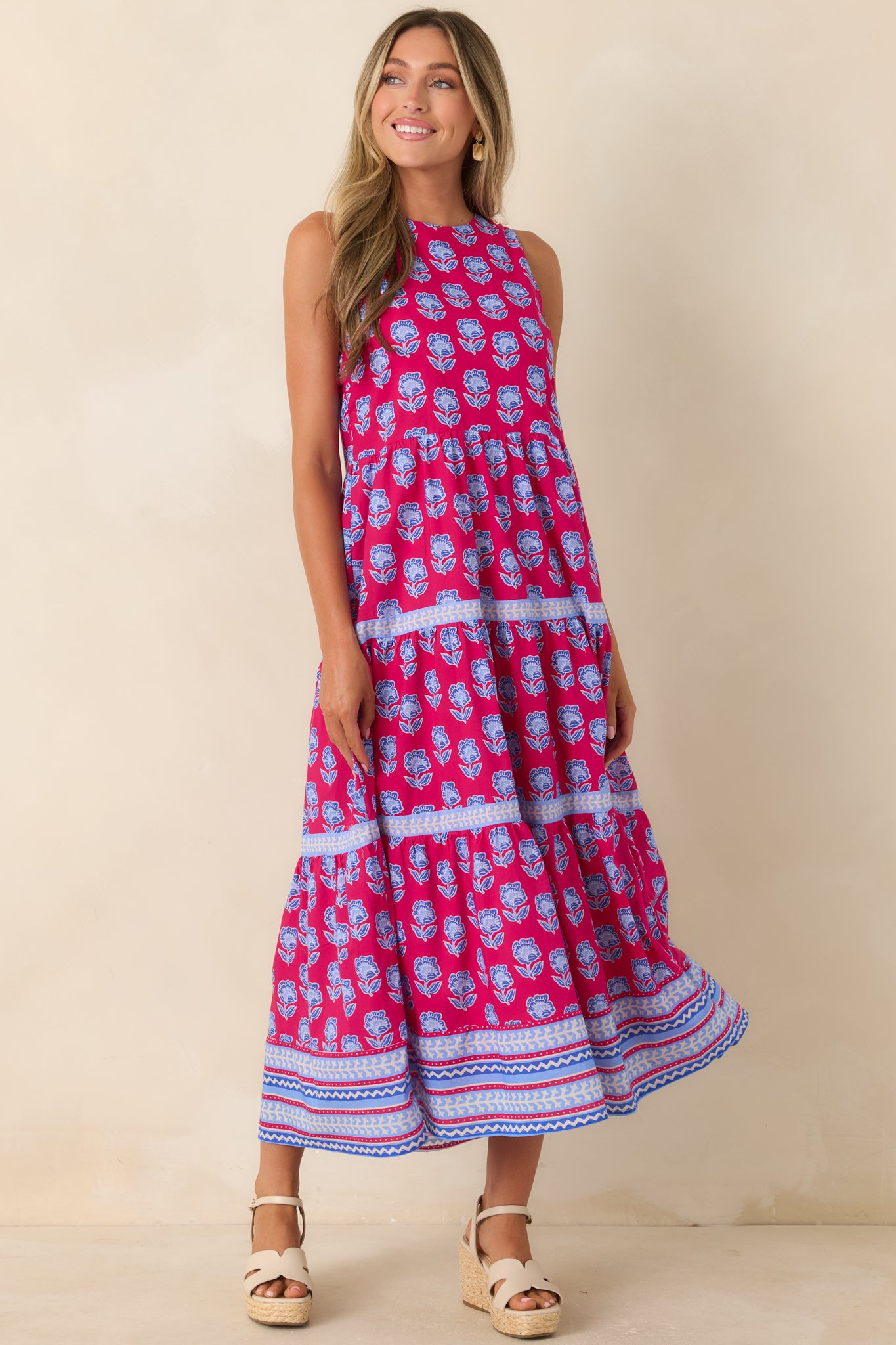 Magenta cotton midi dress featuring a colorful blue floral print, sleeveless design, and softly flowing tiered skirt.