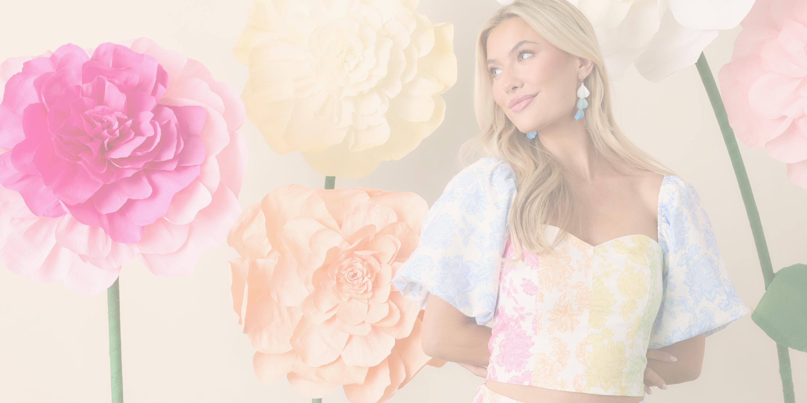 Woman wearing a floral two piece set with large flowers in the background