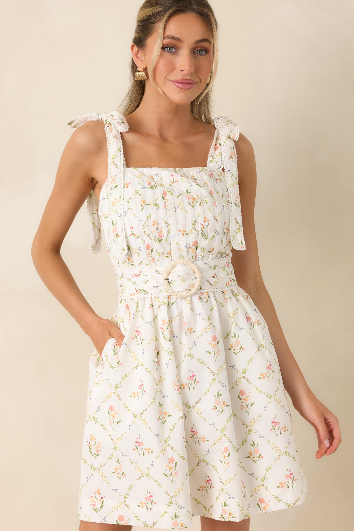 Matching belt with circular buckle defining the waist on floral dress.