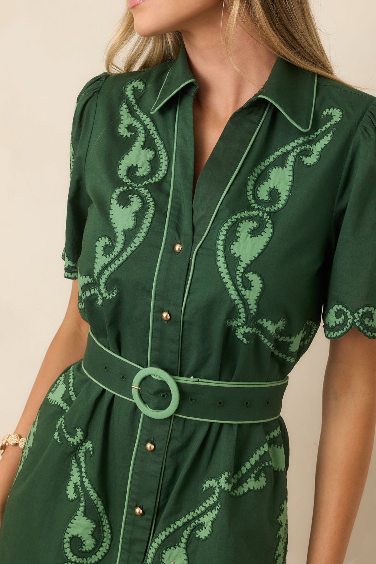 Close view of the matching buckle belt, defined waist, and coordinating printed cotton.