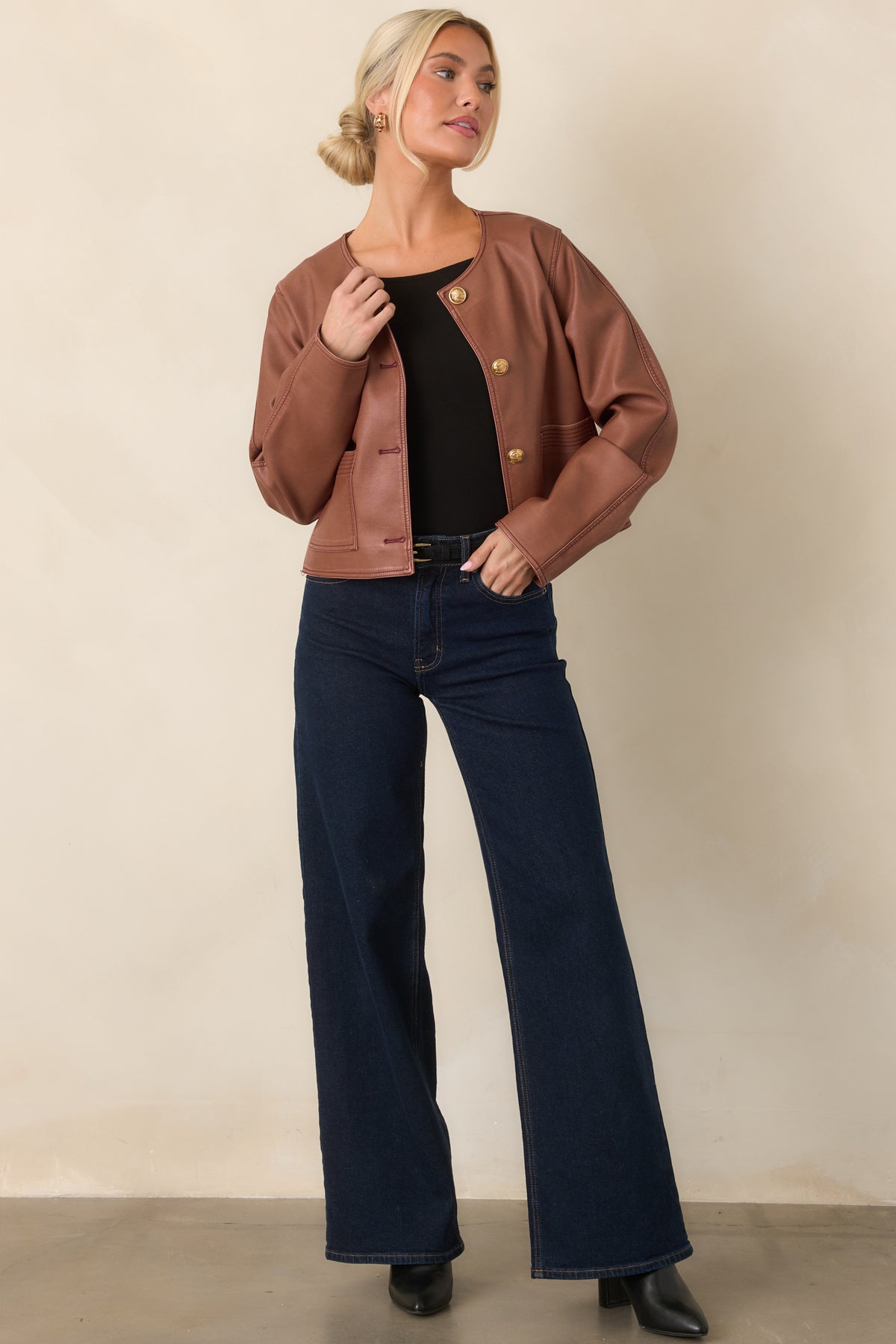 Mauve faux leather cropped jacket with a round neckline, long sleeves, and embossed gold button closure.