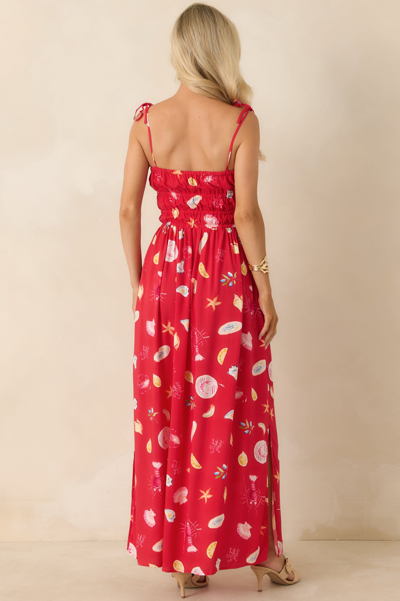 Back view of the maxi dress highlighting the tie straps, smocked bodice, and flowing skirt.