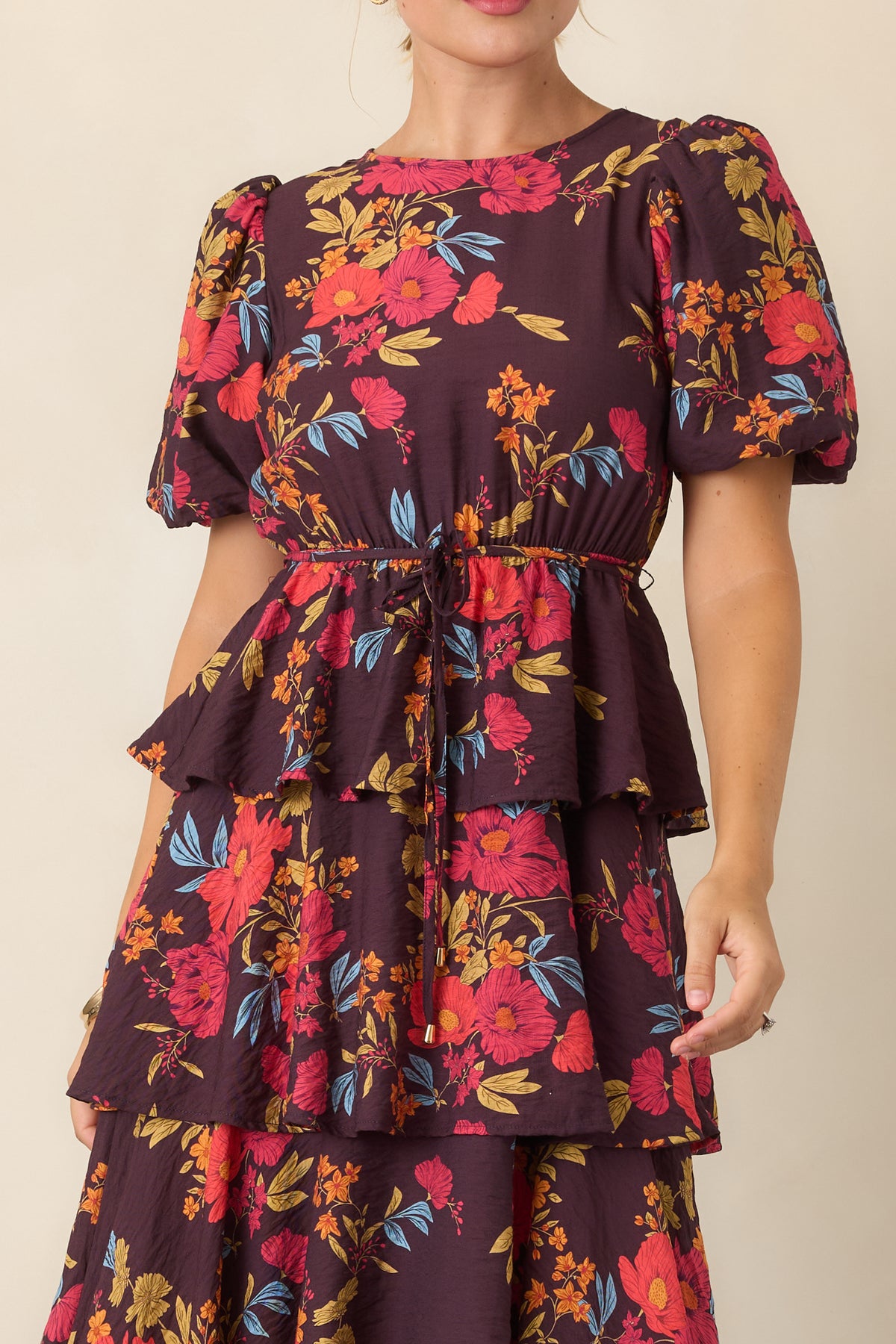 Close-up detail of the dress highlighting the gathered waist and peplum-inspired layer.