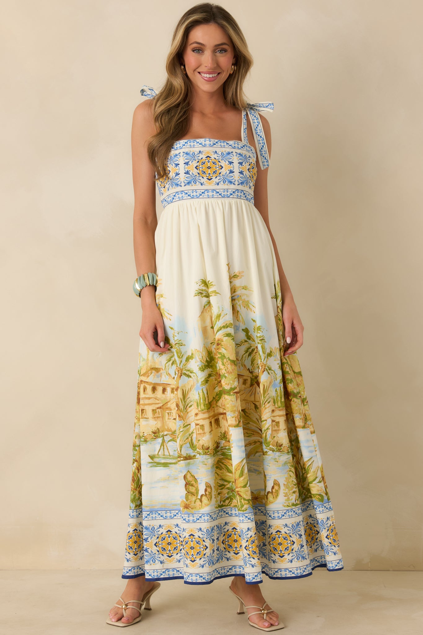 Maxi dress in ivory with tie shoulder straps, structured bodice, and full skirt.