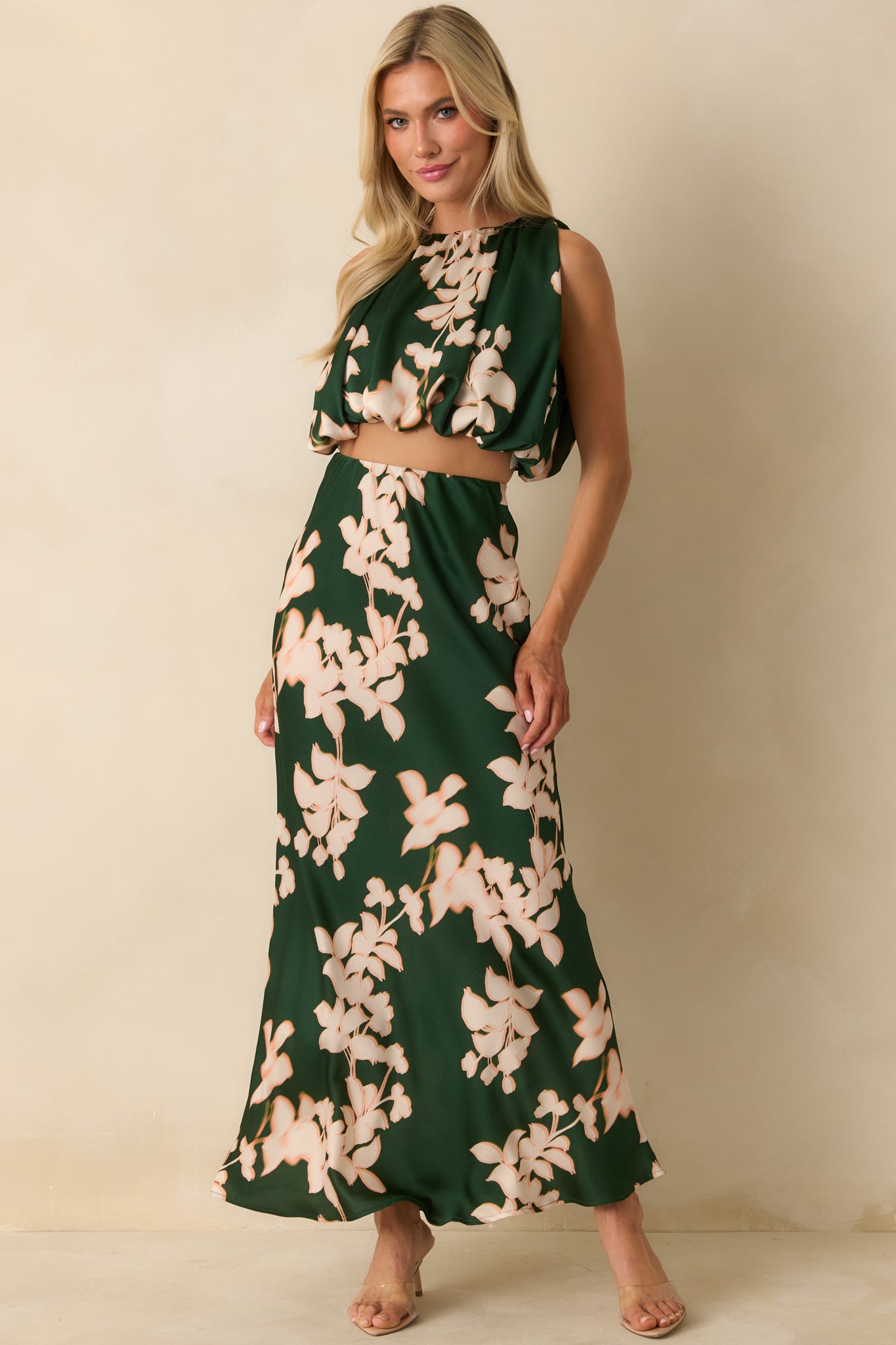 The maxi skirt shows its green floral hammered satin fabric with a bias-cut silhouette and flowing full length.