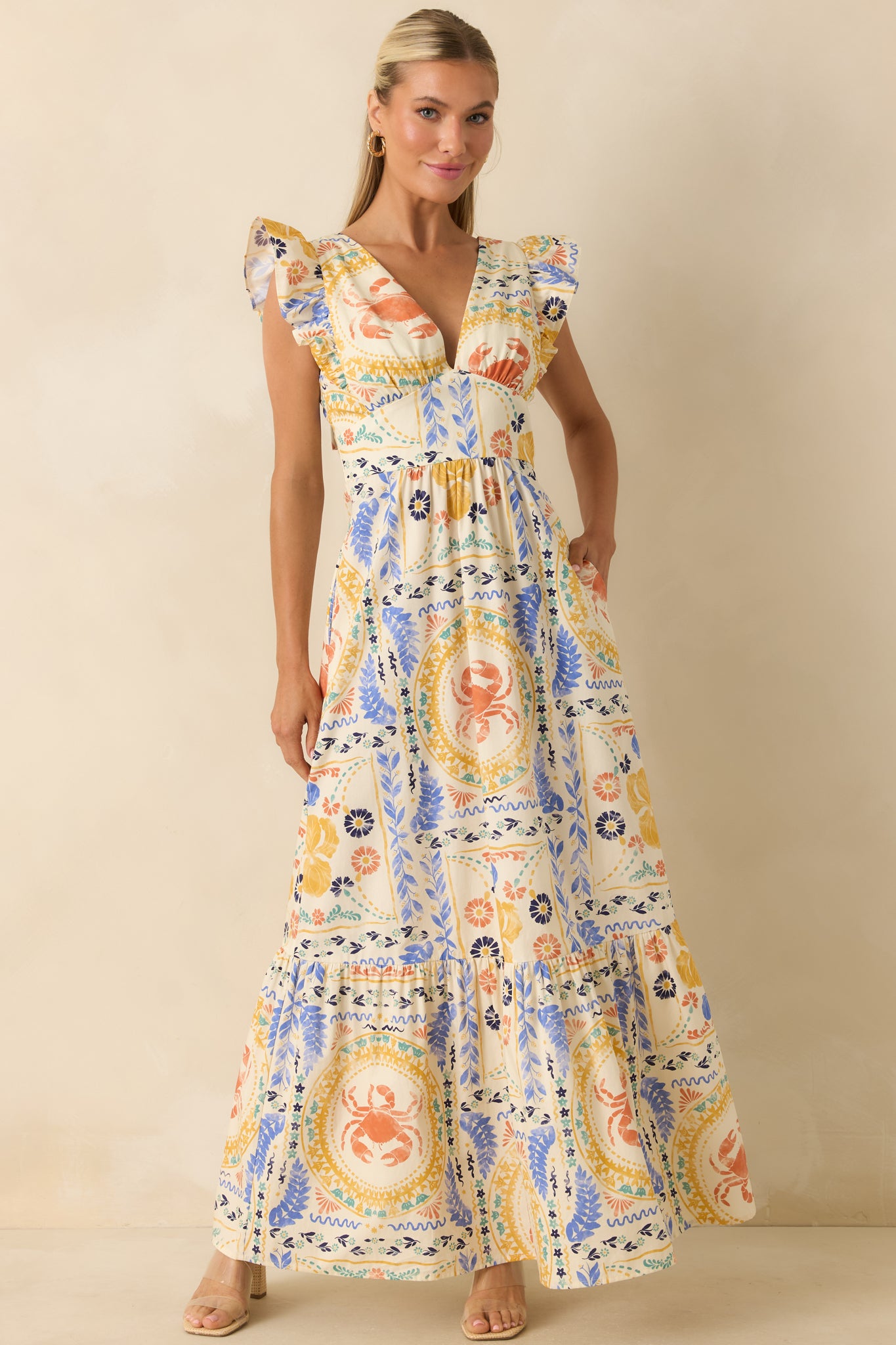 Maxi dress showcasing a vibrant patchwork design with crabs, shells, florals, and Mediterranean motifs, finished with a gathered waist and tiered skirt.