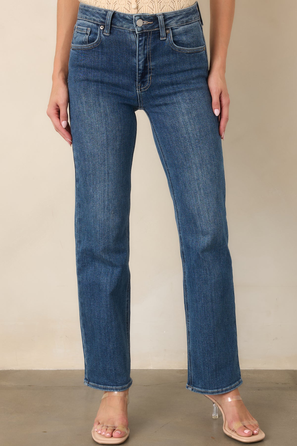 Detailed view of the medium blue denim showcasing subtle fading through the upper leg and clean straight-leg construction.