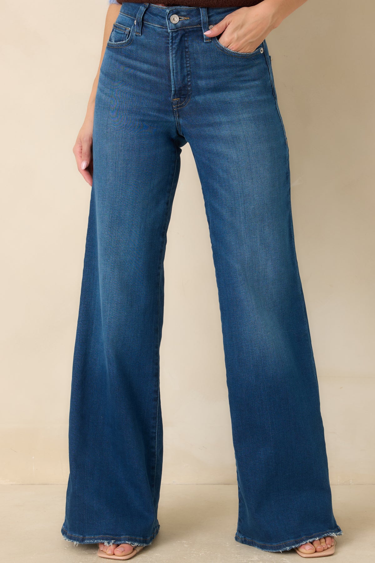 Medium blue stretch jeans with subtle whiskering across the hips and a classic five-pocket design.