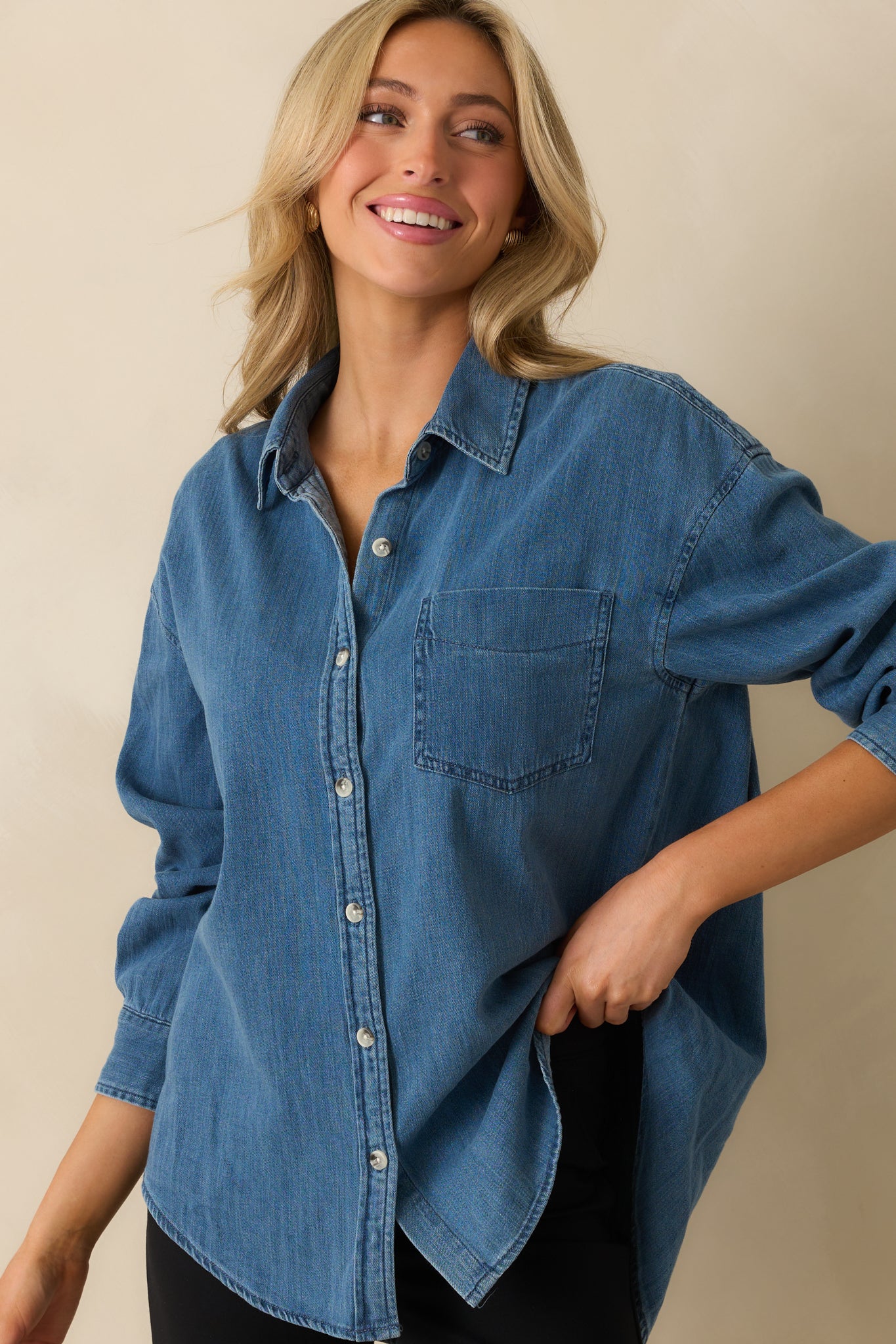 Medium wash cotton blend top with collar neckline and long sleeves.