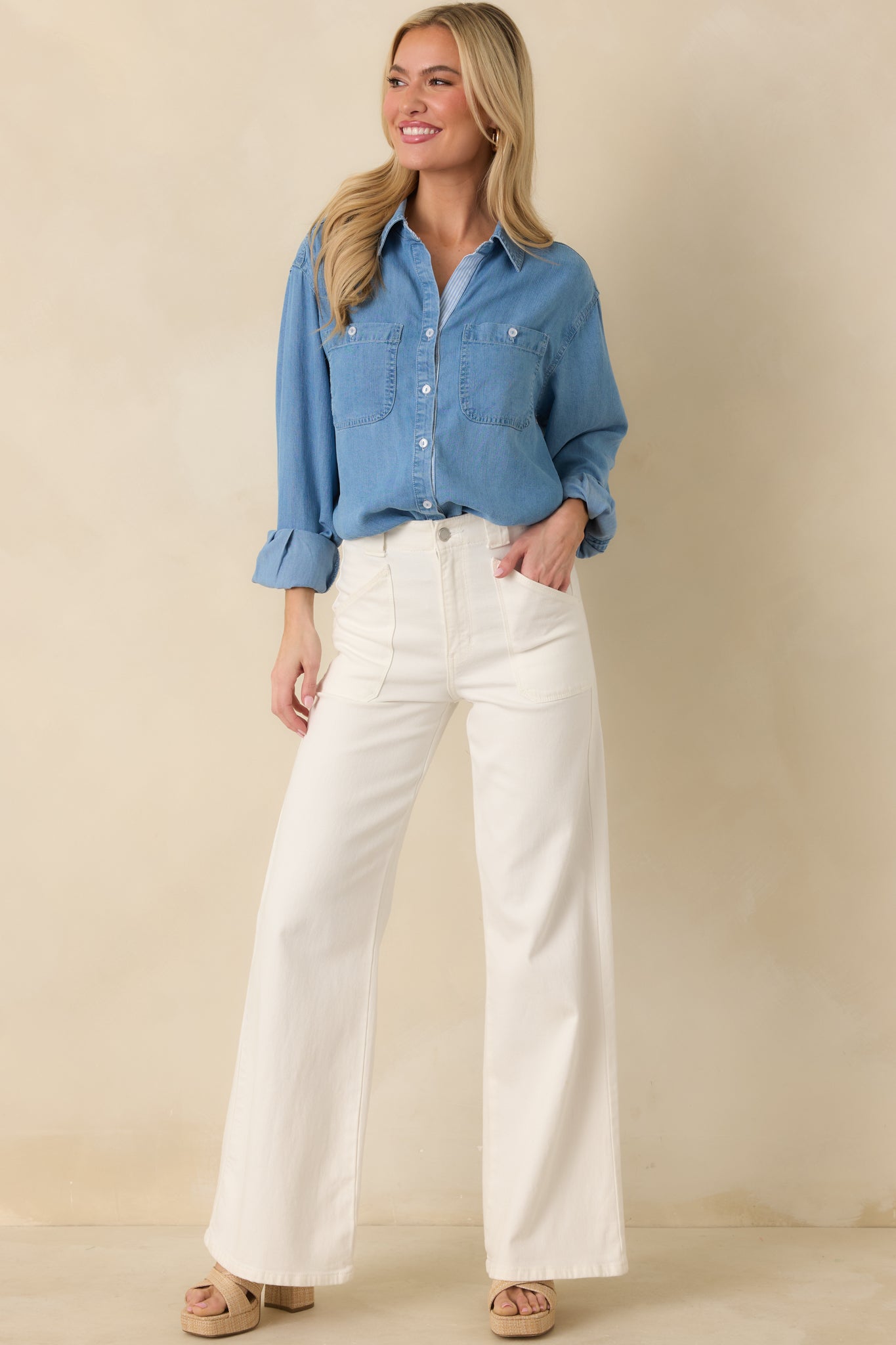 Front view of the medium wash denim button-up shirt featuring a classic collar, relaxed fit, and dual chest patch pockets.