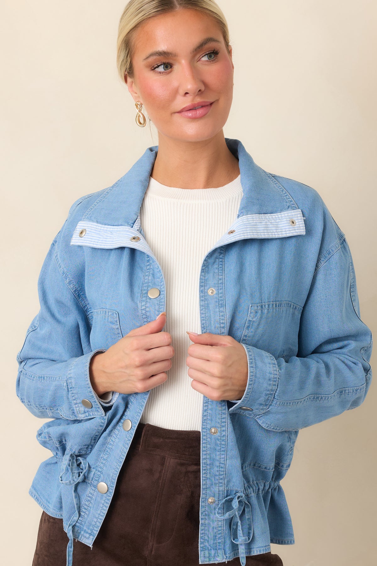 Medium wash denim top with an adjustable drawstring waist creating a subtle peplum silhouette.