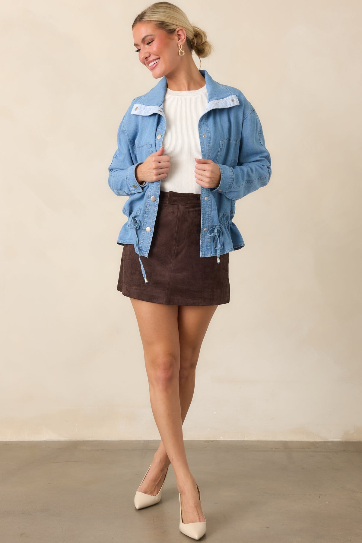 Medium wash denim layer with a classic collar, relaxed fit, and softly gathered peplum hem.